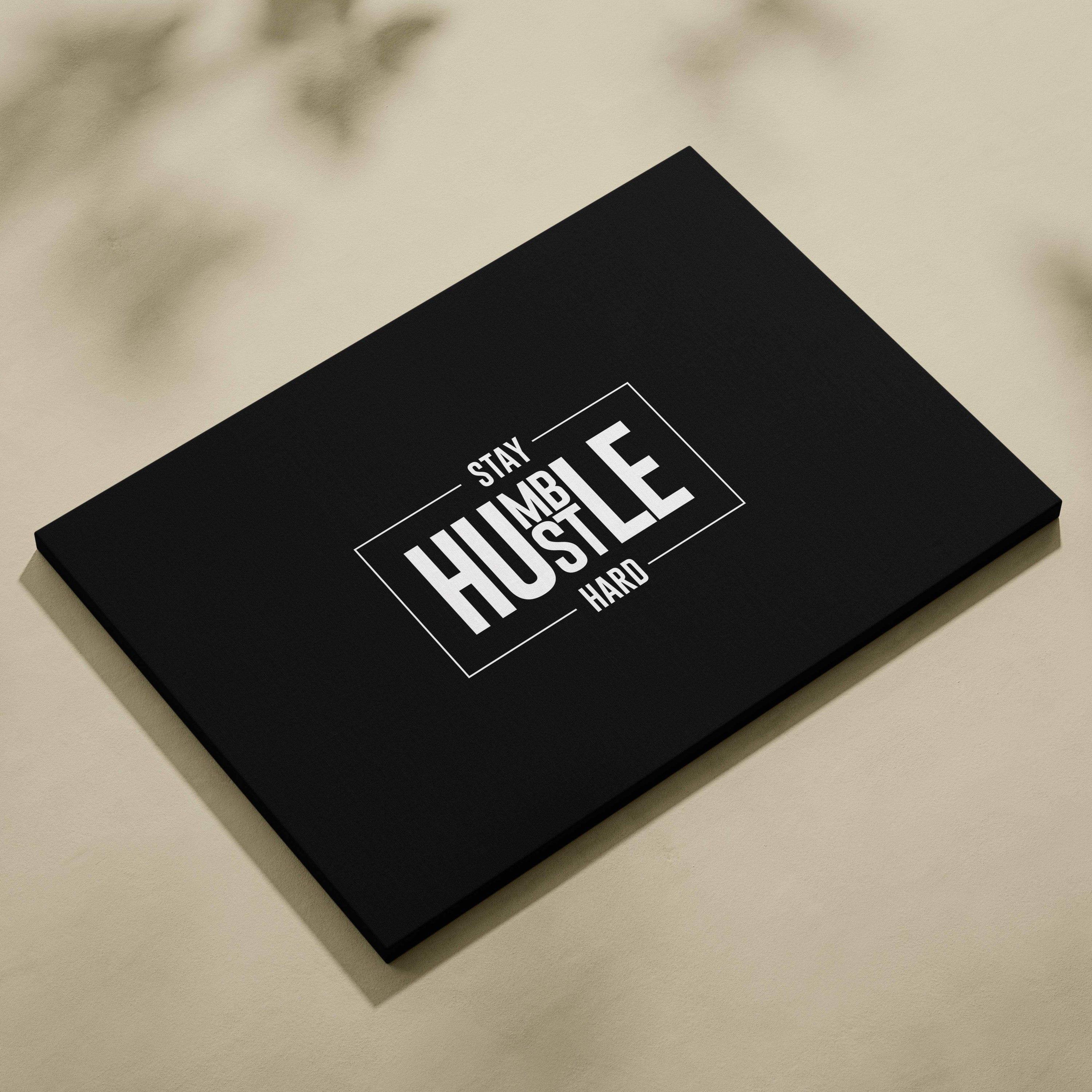 Black canvas print featuring stay humble hustle hard white text in bold modern font with minimalist rectangular border