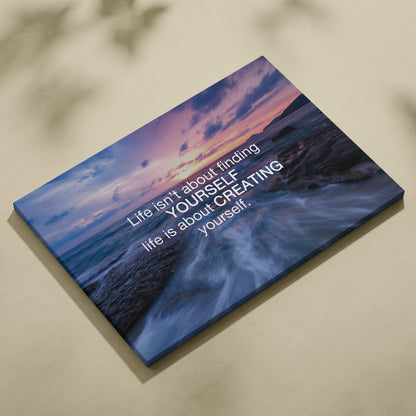 A rectangular canvas print of a vibrant ocean sunset with a motivational life is about creating yourself quote in white text