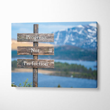Rustic wooden canvas wall art with progress not perfection sign against blue mountain and lake landscape backdrop
