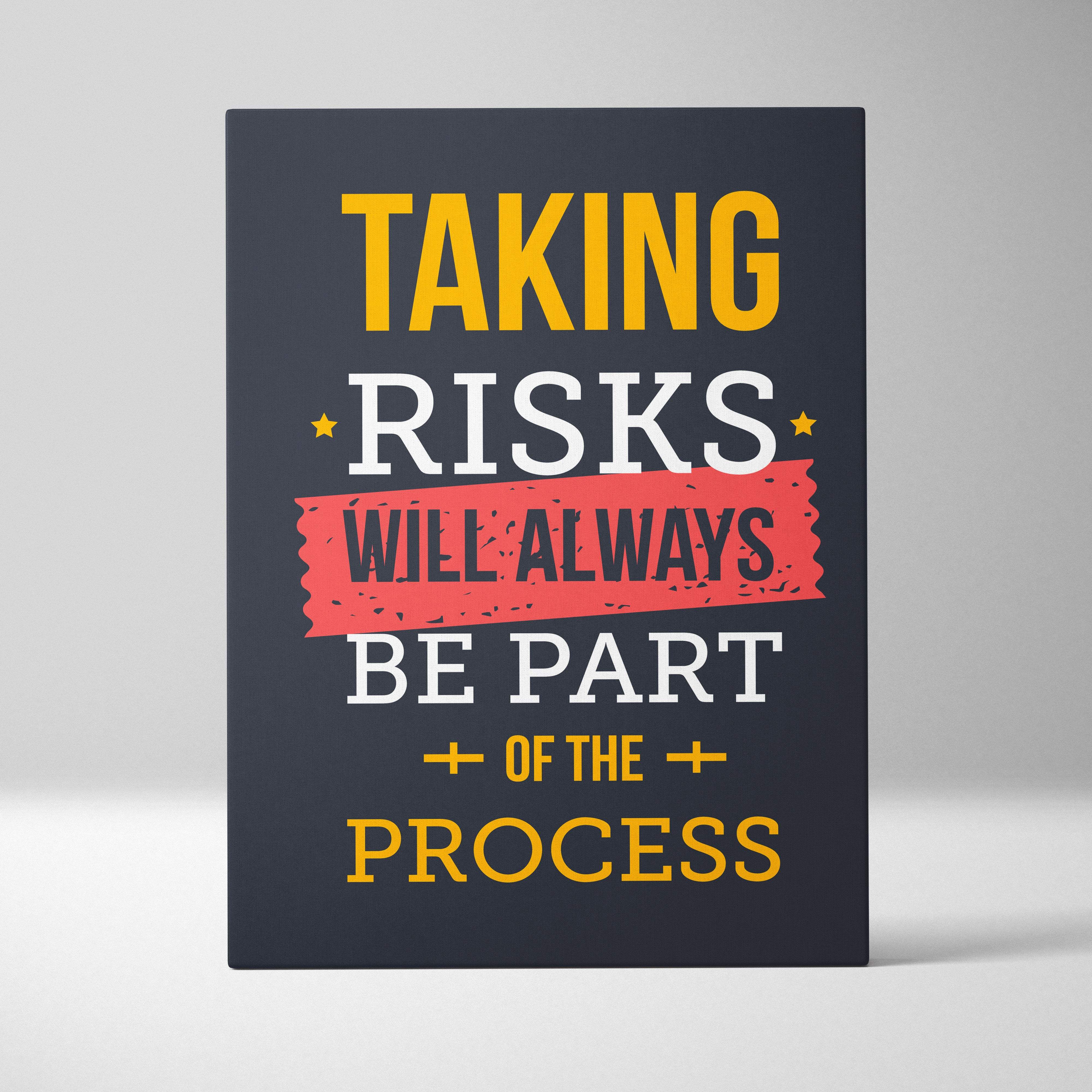 Dark navy canvas print with bold yellow and white text and a distressed red banner reading taking risks will always be part of the process motivational wall art for office or home