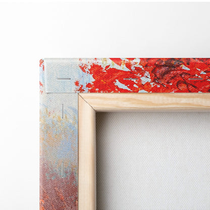 A vibrant abstract canvas painting with bold red blue and white splatters in a light wood frame wall art