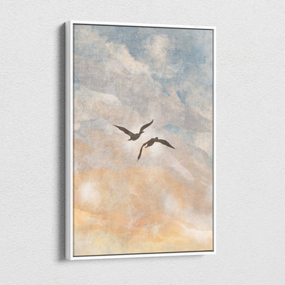 A framed canvas print of two dark silhouetted birds in flight against a soft blue peach and neutral watercolor sky