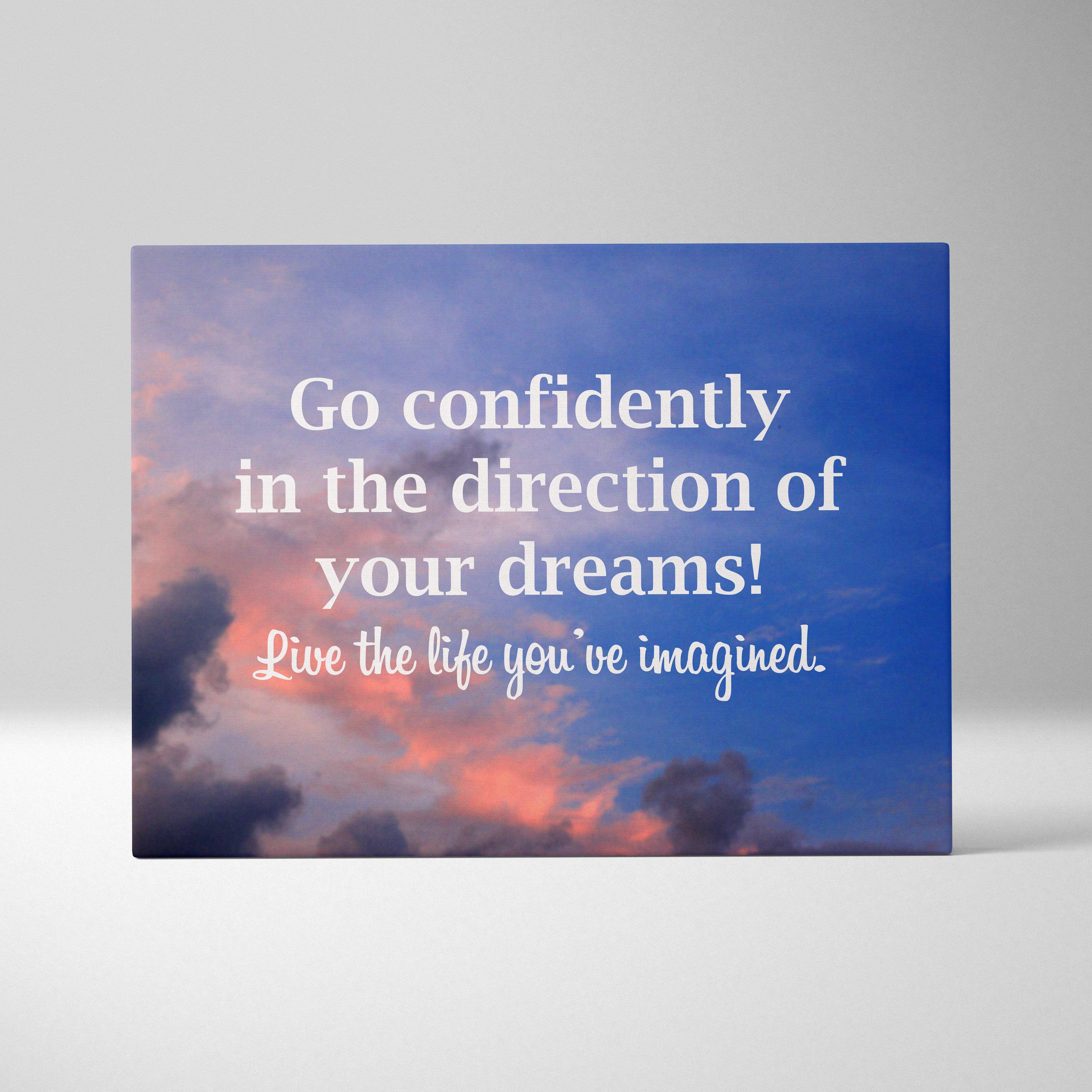 Blue canvas print with pink and orange clouds featuring an inspirational go confidently in the direction of your dreams quote