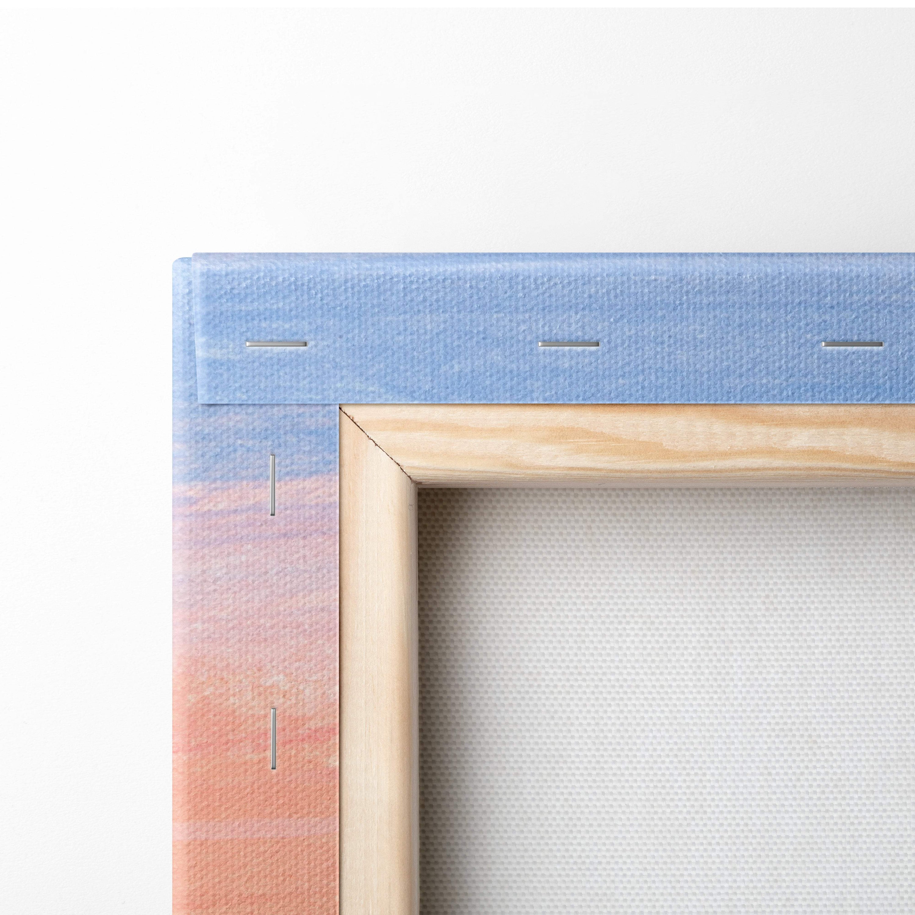A light wood-framed canvas print with a blue to peach gradient border and visible stitching for vibrant city skyline wall art
