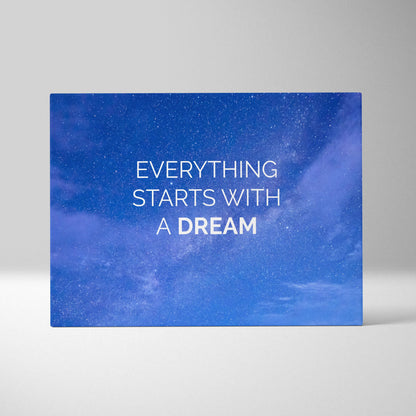 Blue canvas print with inspirational everything starts with a dream quote on starry night sky for home or office decor