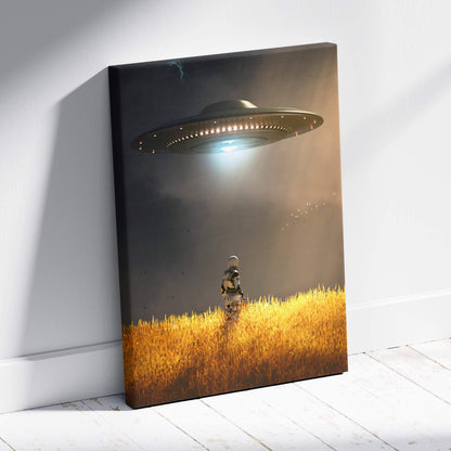 Canvas print of a dark metallic ufo hovering over golden wheat fields with a lone astronaut figure below