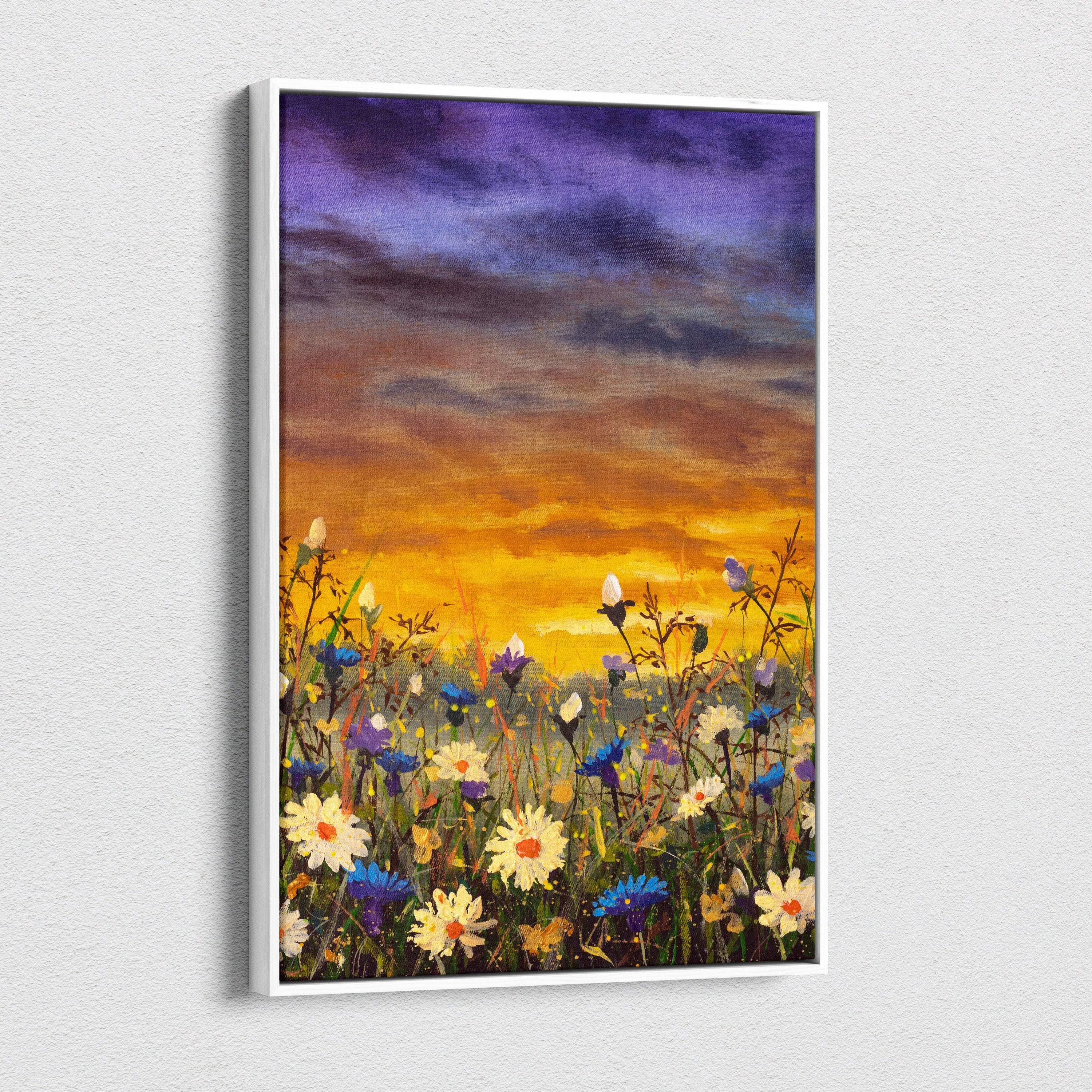 A rectangular canvas print with a white frame showing a vibrant wildflower meadow under a golden orange sunset sky