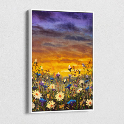 A rectangular canvas print with a white frame showing a vibrant wildflower meadow under a golden orange sunset sky