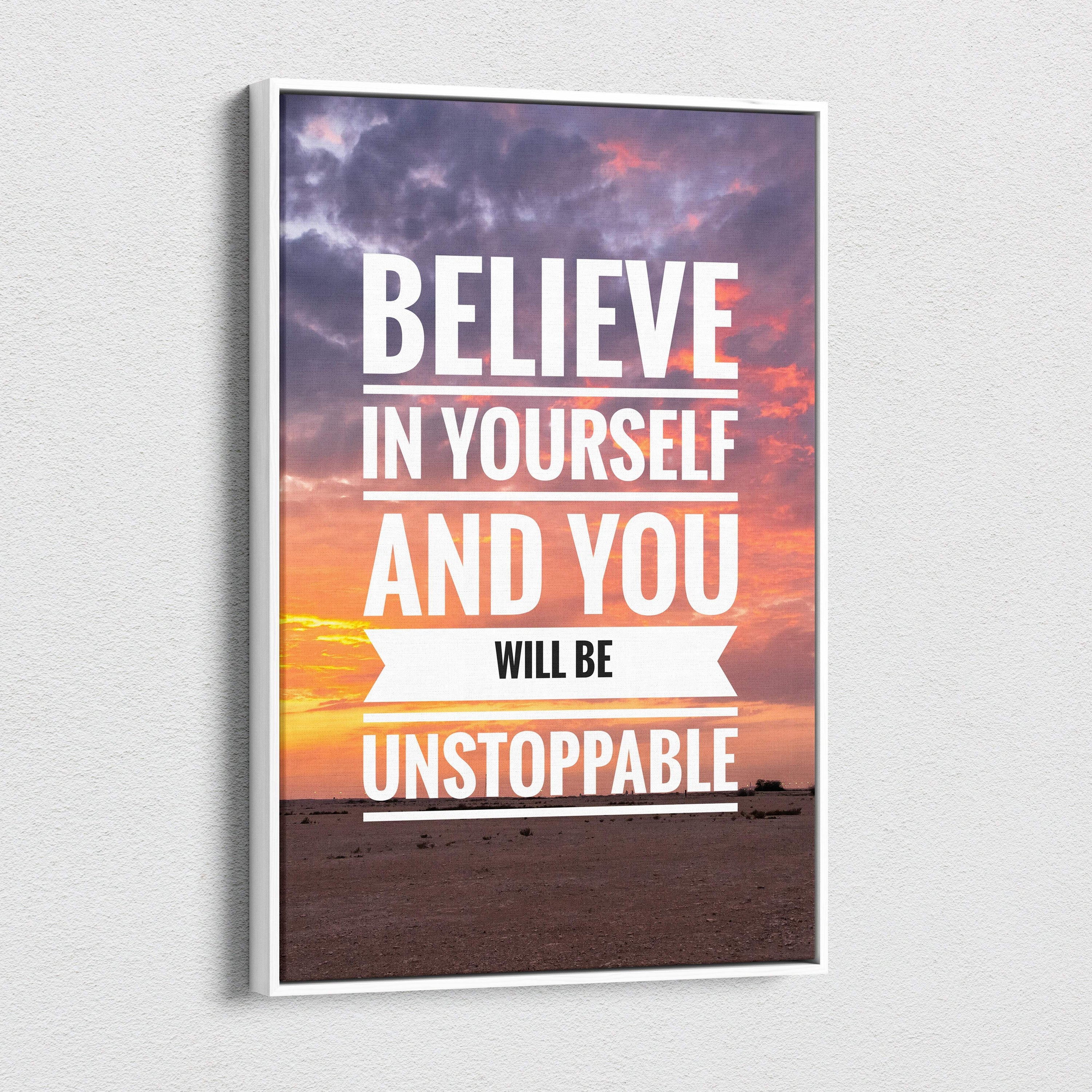 White-framed motivational canvas print with believe in yourself quote over purple and orange sunset sky for office or home