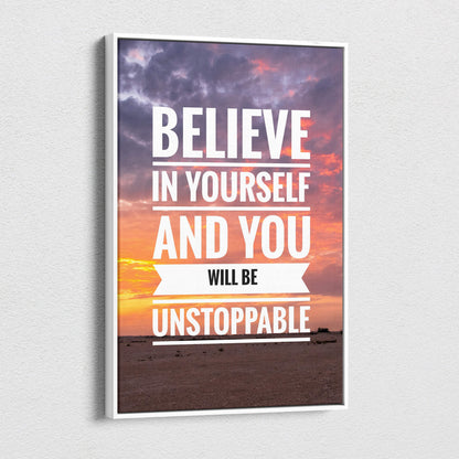 White-framed motivational canvas print with believe in yourself quote over purple and orange sunset sky for office or home