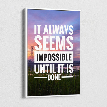 White-framed canvas print featuring the motivational quote it always seems impossible until it is done on a sunset landscape