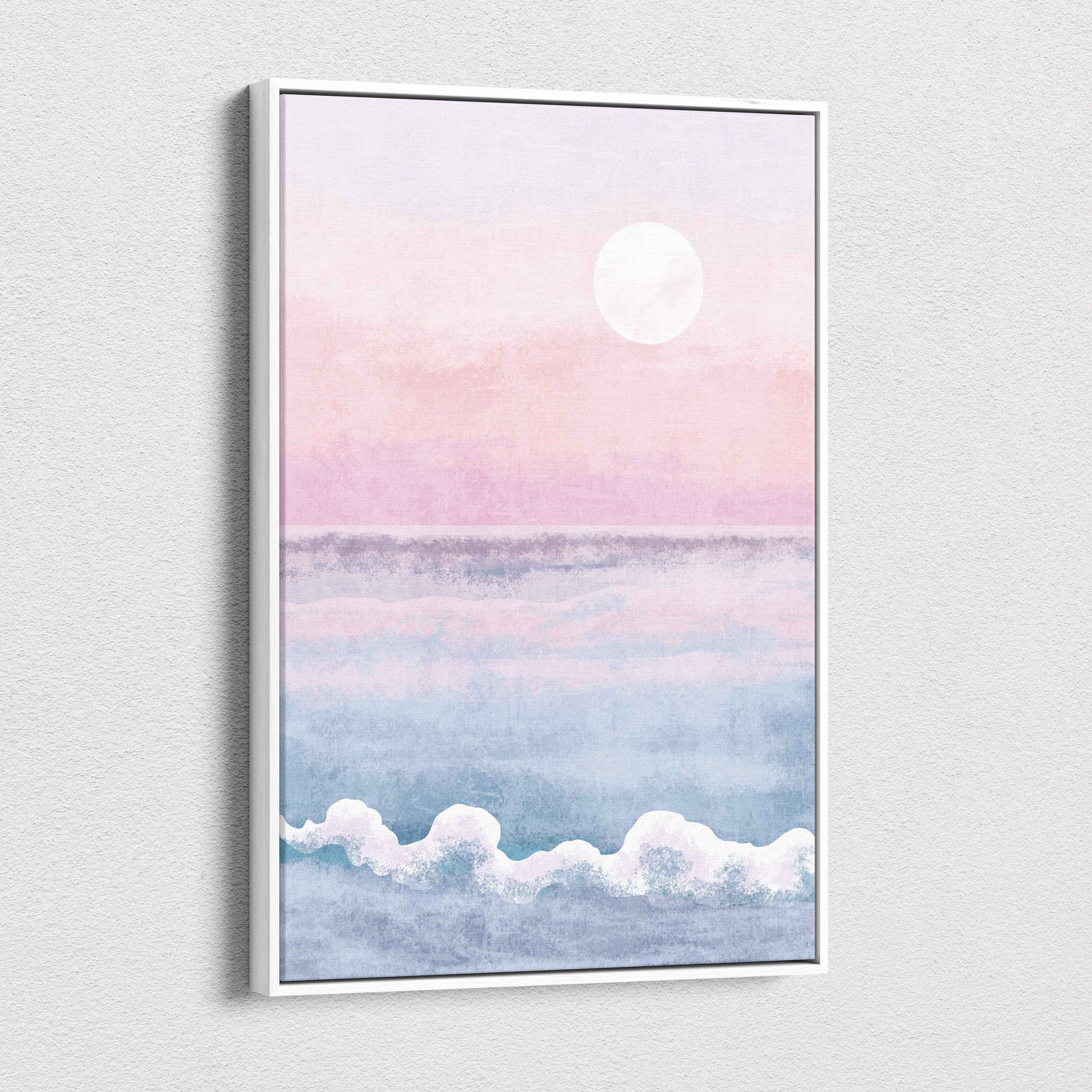 A framed watercolor boho pastel ocean sunset canvas art with pink and blue hues in a sleek white frame