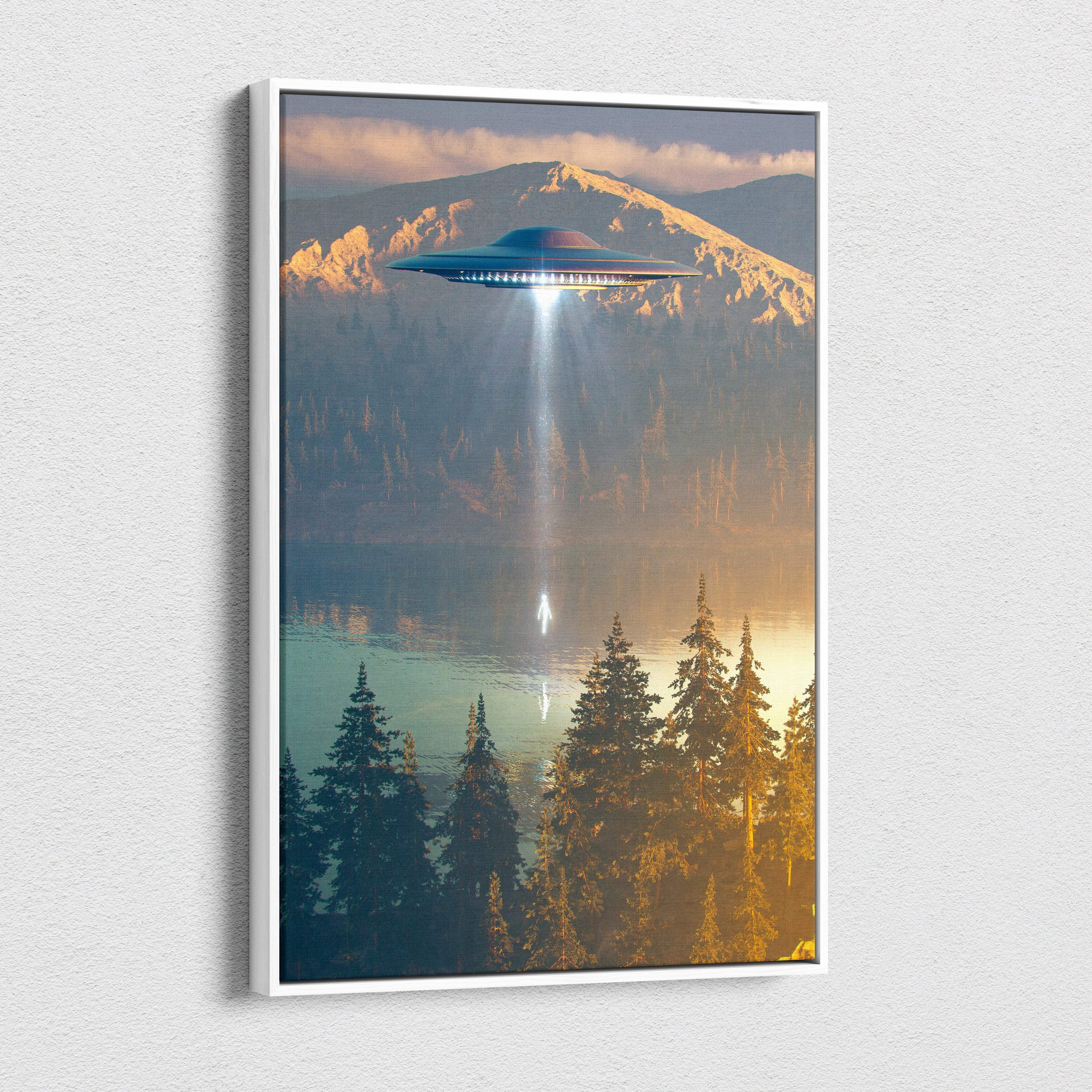 A framed canvas print of a sleek metallic blue ufo hovering over a mountain lake with golden light beams shining down