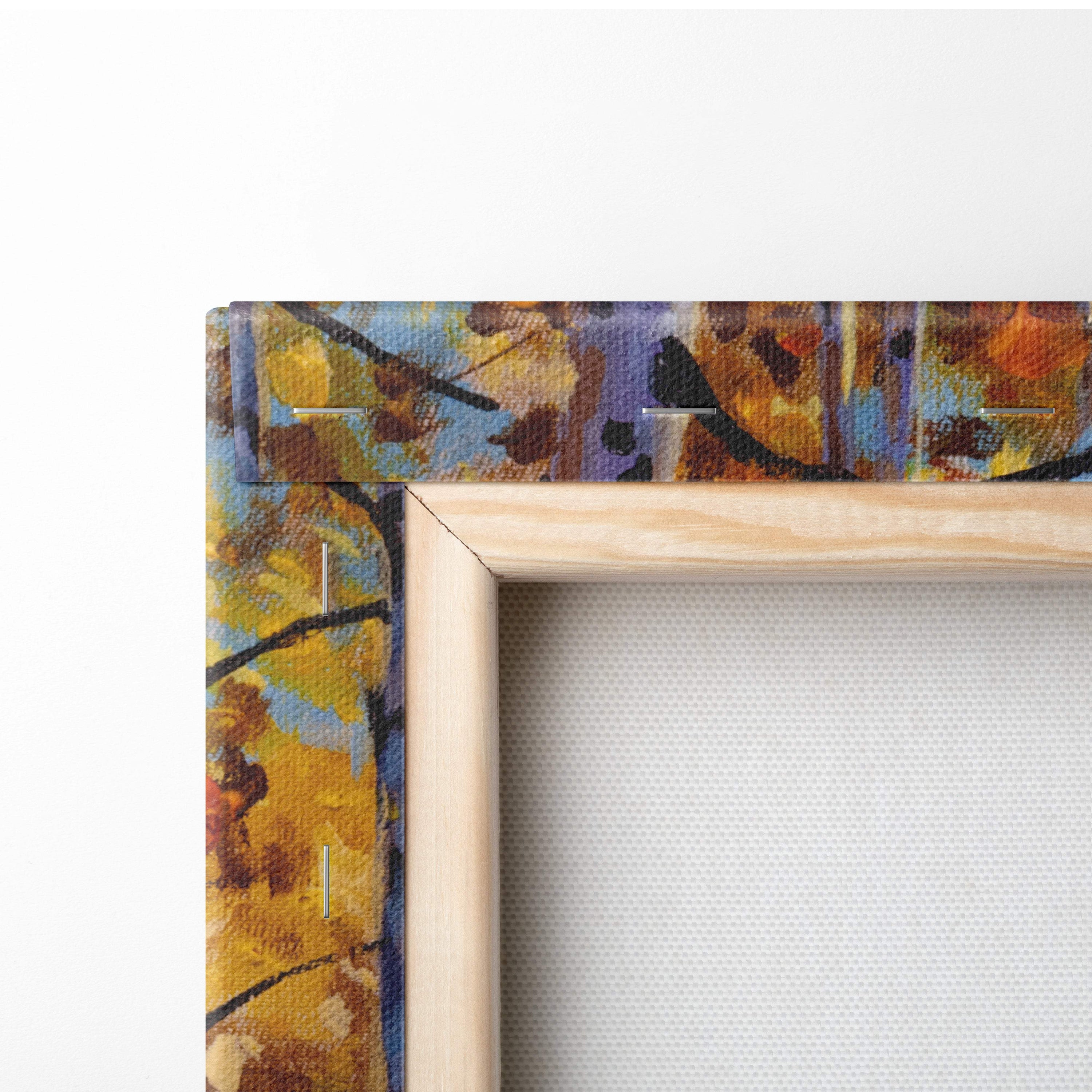 A wooden frame holding an autumn birch forest canvas print with yellow orange and purple abstract brushstrokes