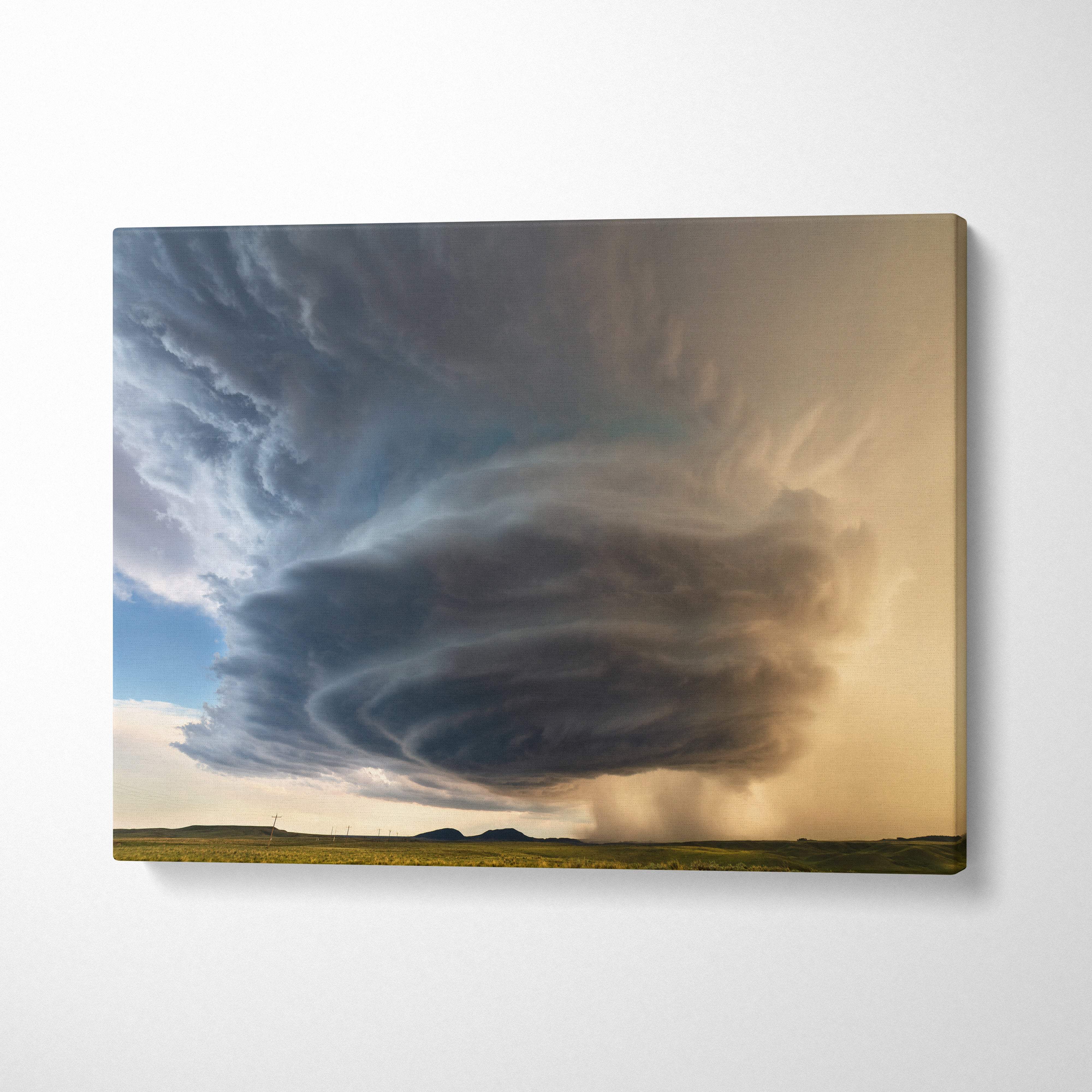 Canvas print of a supercell thunderstorm with swirling dark gray clouds and golden sky over an open field wall decor