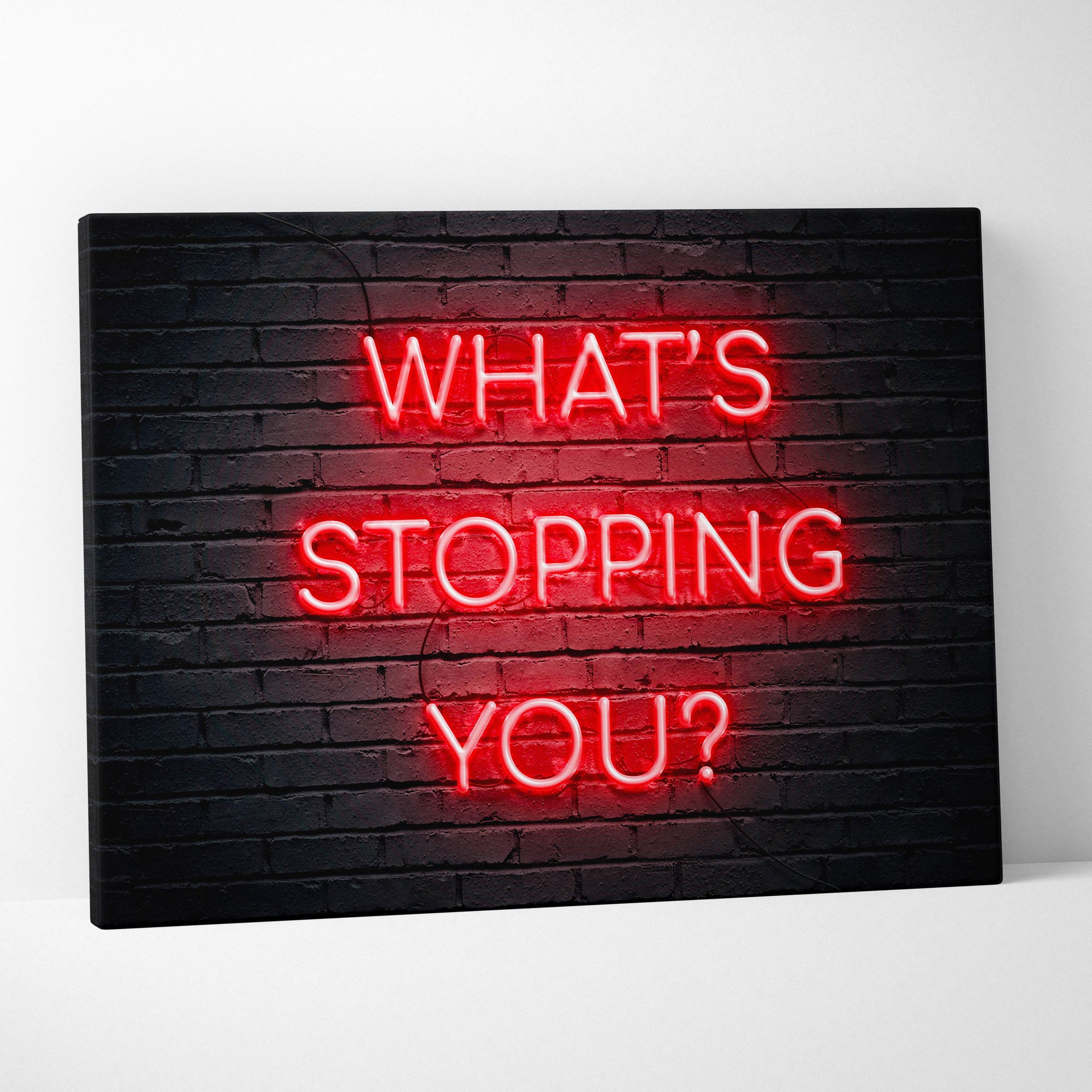 Red neon sign reading whats stopping you mounted on black brick wall motivational wall art print for office gym or bedroom