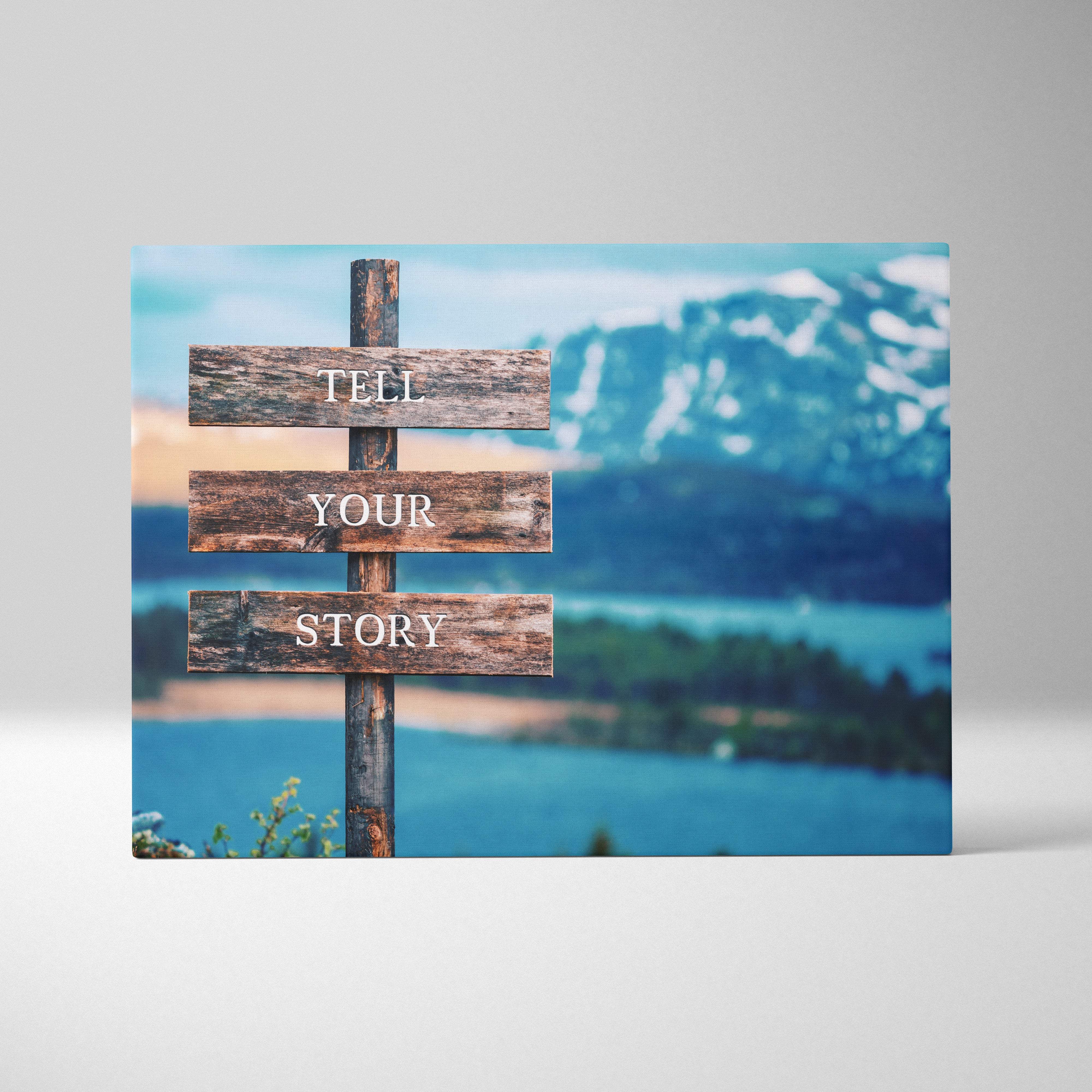 Rustic wooden sign with tell your story lettering on weathered planks mounted on a post with mountain backdrop