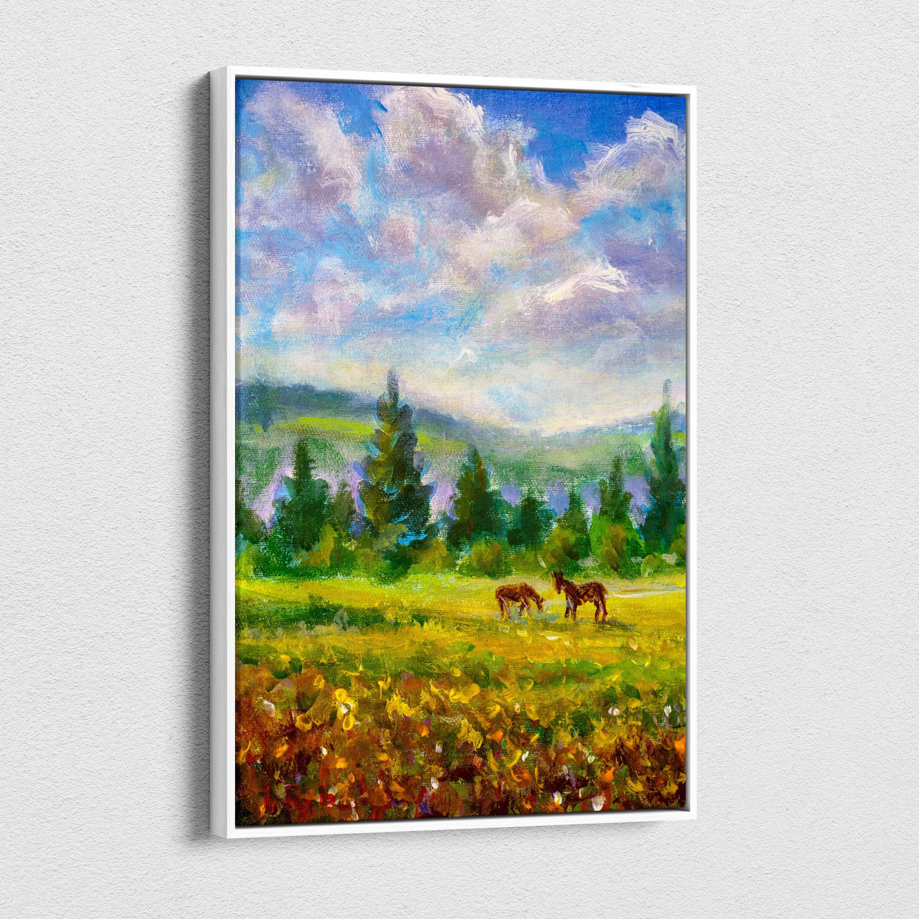 A framed impressionist canvas print of two brown horses grazing in a sunlit meadow under a soft cloudy sky