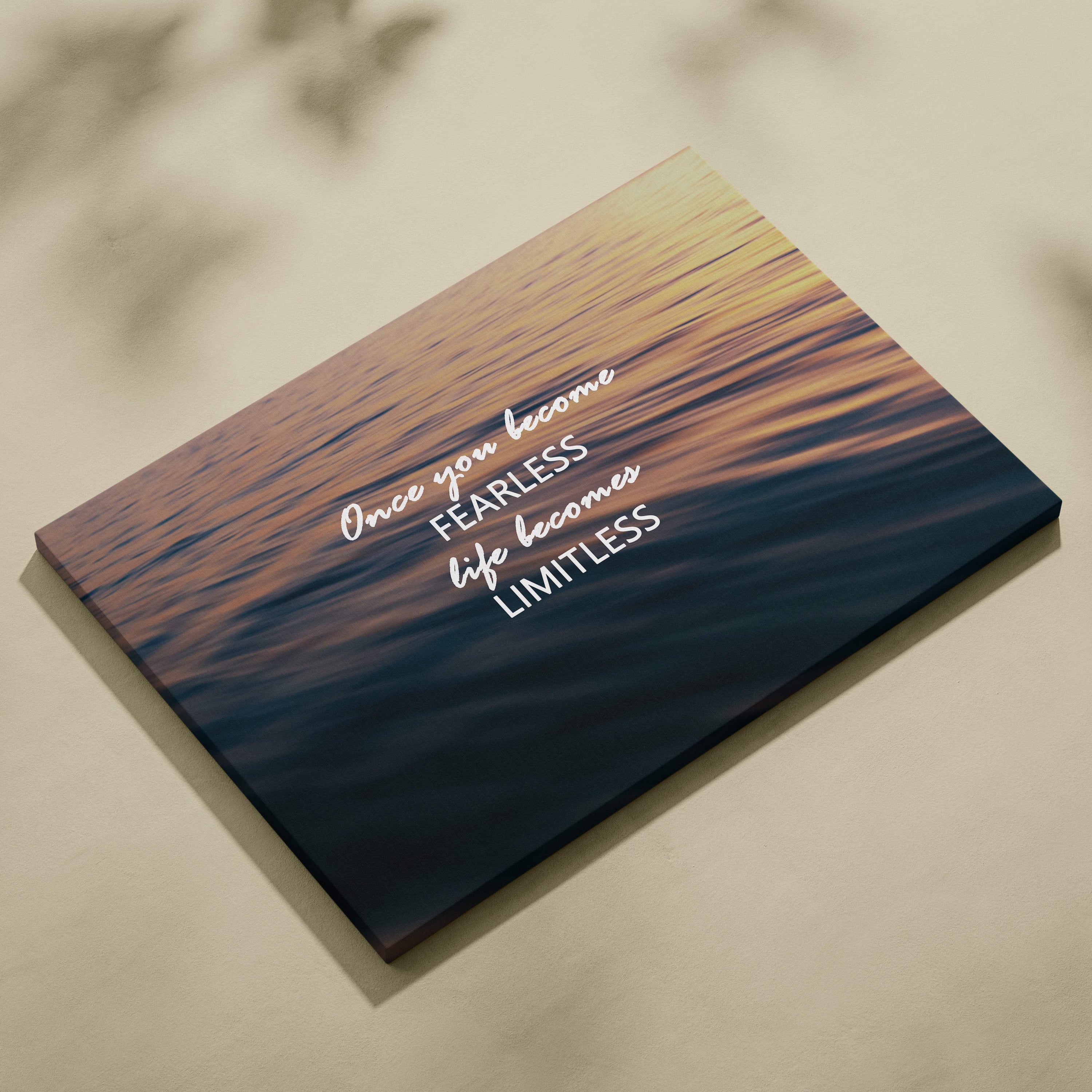 Rectangular canvas print of a serene sunset over water with fearless and limitless inspirational white script for decor