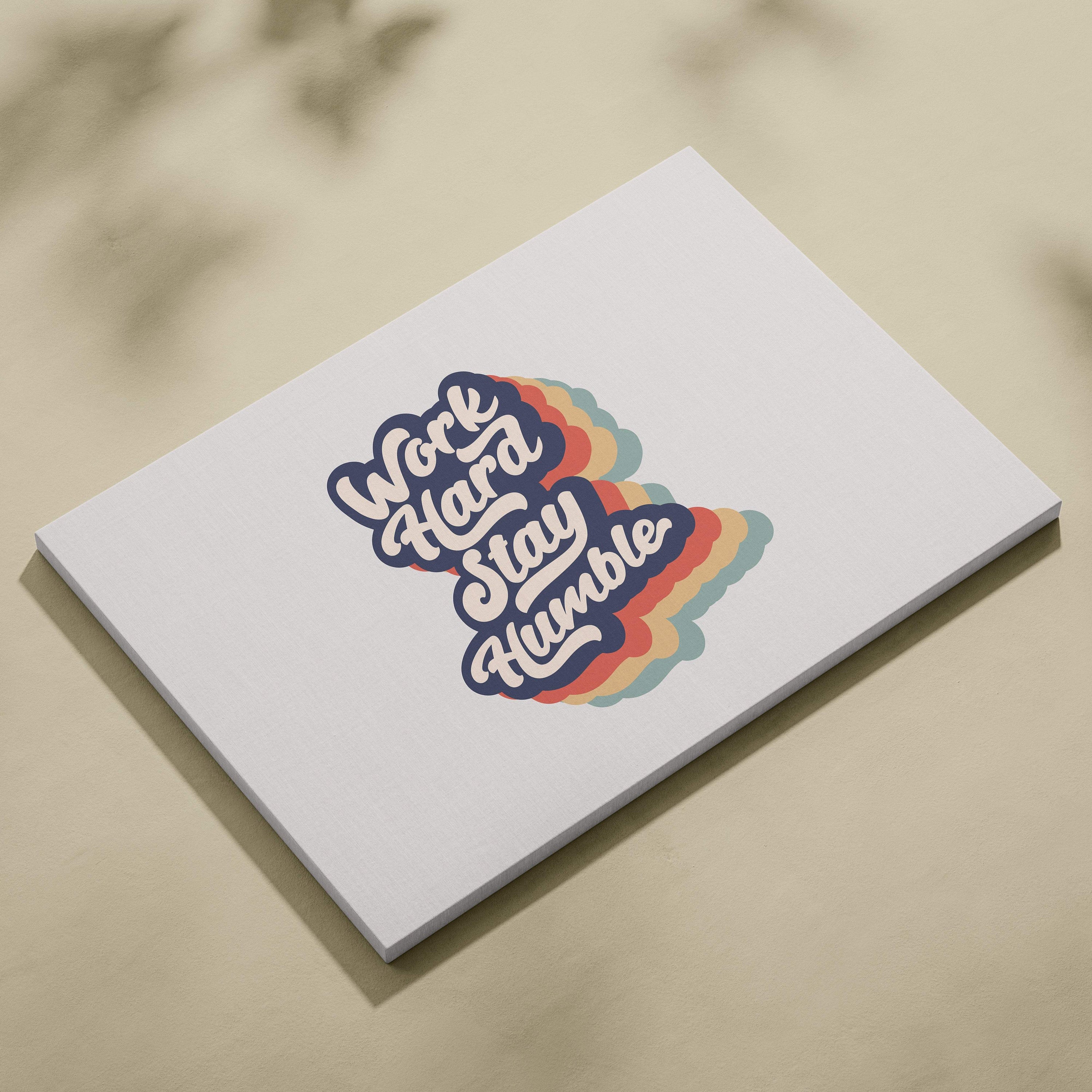 White rectangular notepad with colorful retro work hard stay humble graphic and rainbow gradient accents on cover