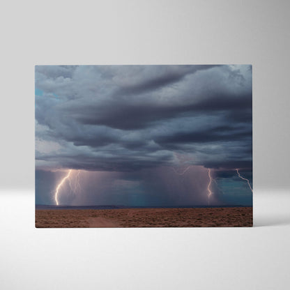 Canvas print of a multiple lightning storm with dark blue thunderclouds over a barren desert landscape wall decor
