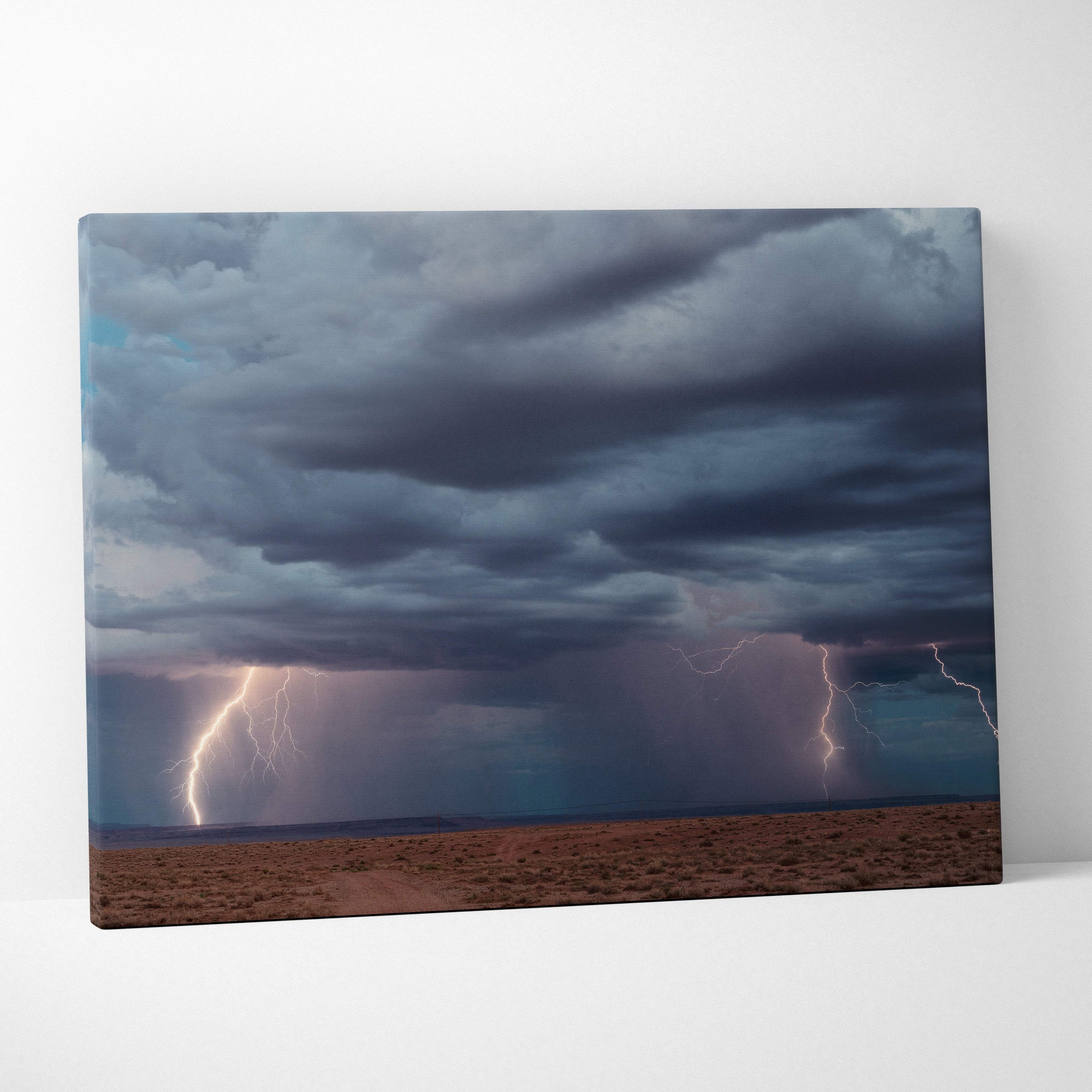 Stormy sky canvas print with dark blue thunderclouds and vivid lightning bolts over a desert landscape wall decor