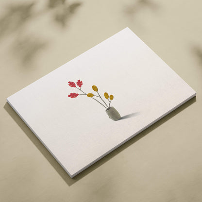 A minimalist white canvas wall art featuring red and yellow leaf branches in a small gray ceramic vase for modern decor