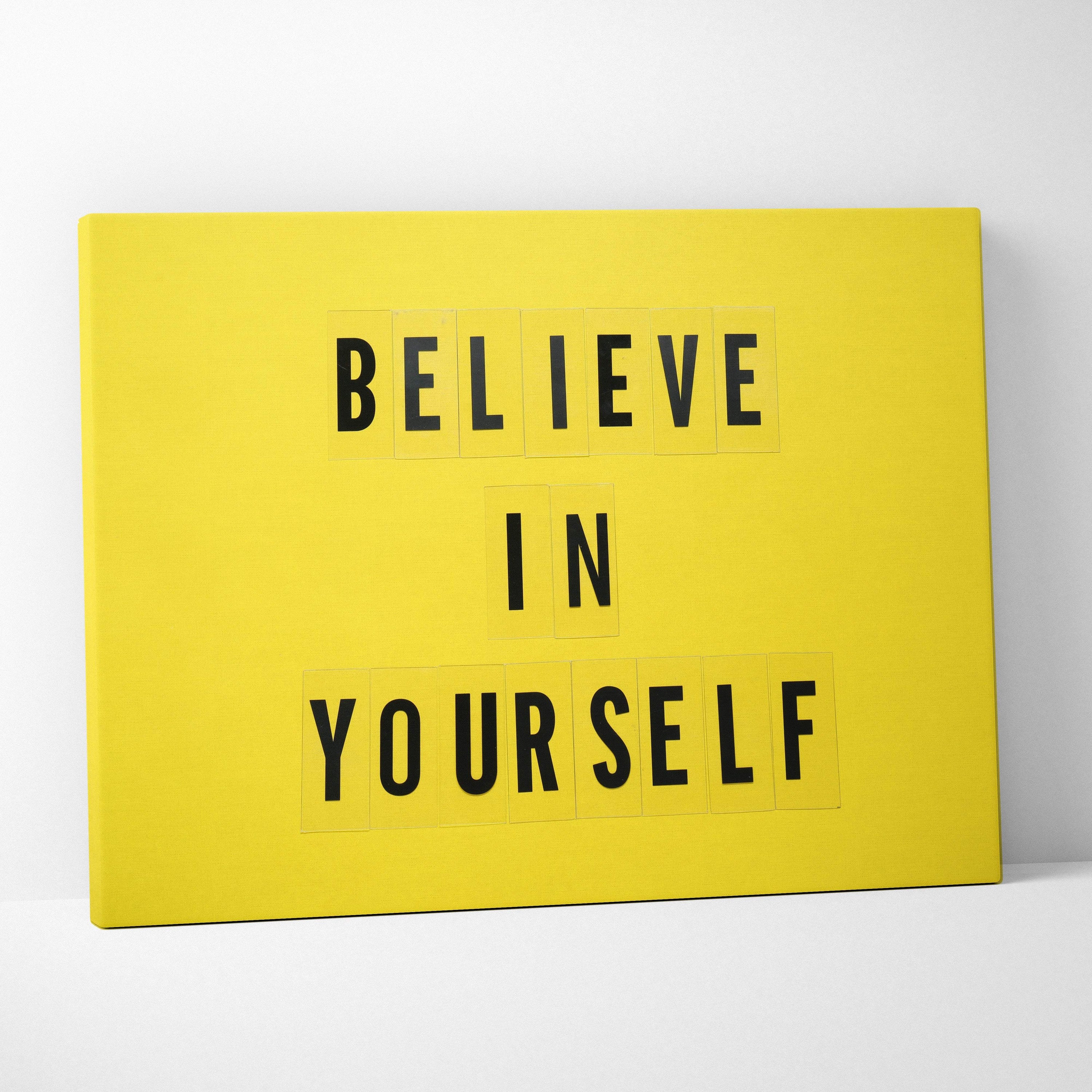 Bright yellow canvas wall art with believe in yourself bold black typography for motivational home or office decor
