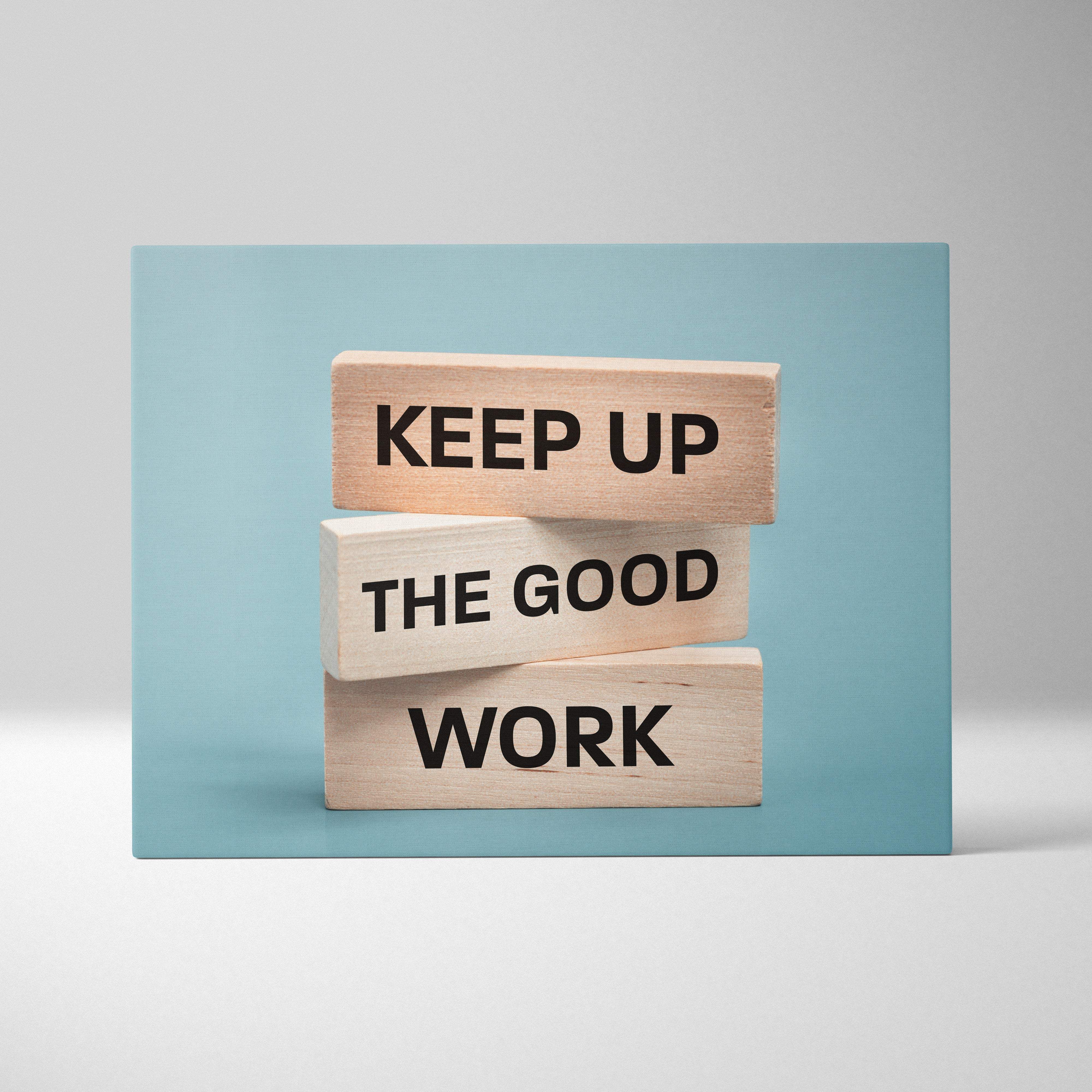 Stacked wooden blocks with black text keep up the good work in a motivational wall art print for office or home decor