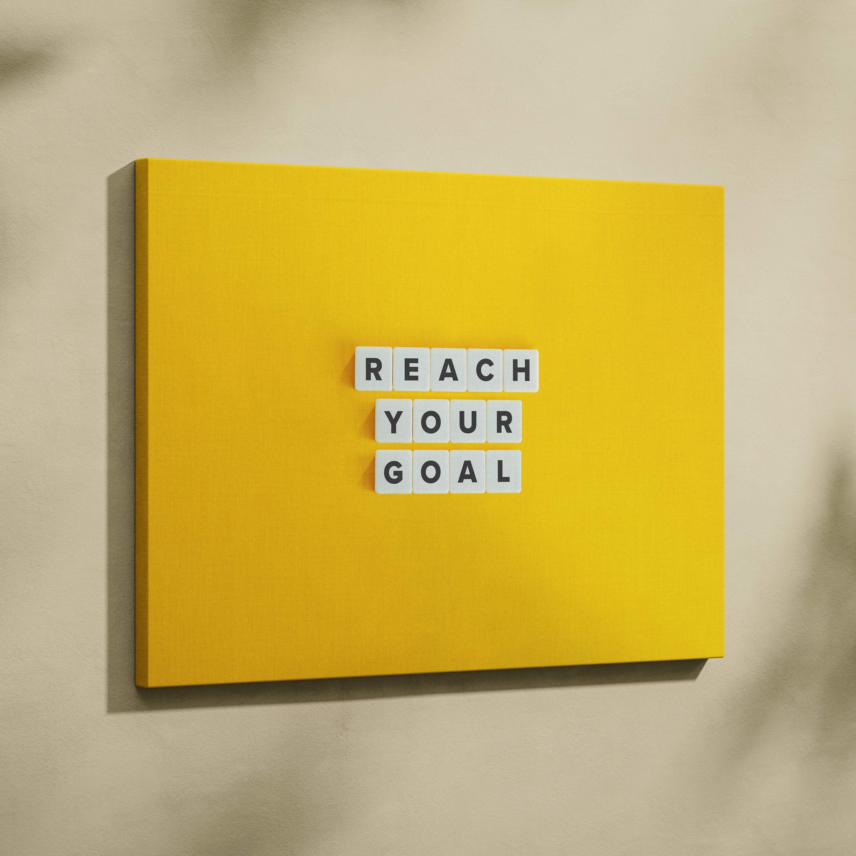 Bright yellow canvas wall art featuring white letter tiles spelling reach your goal motivational quote for office or gym decor
