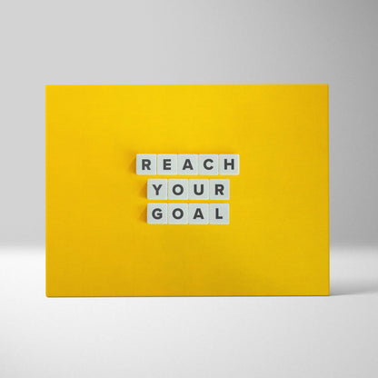 Bright yellow motivational wall art print with reach your goal white letter tiles for office gym or home decor
