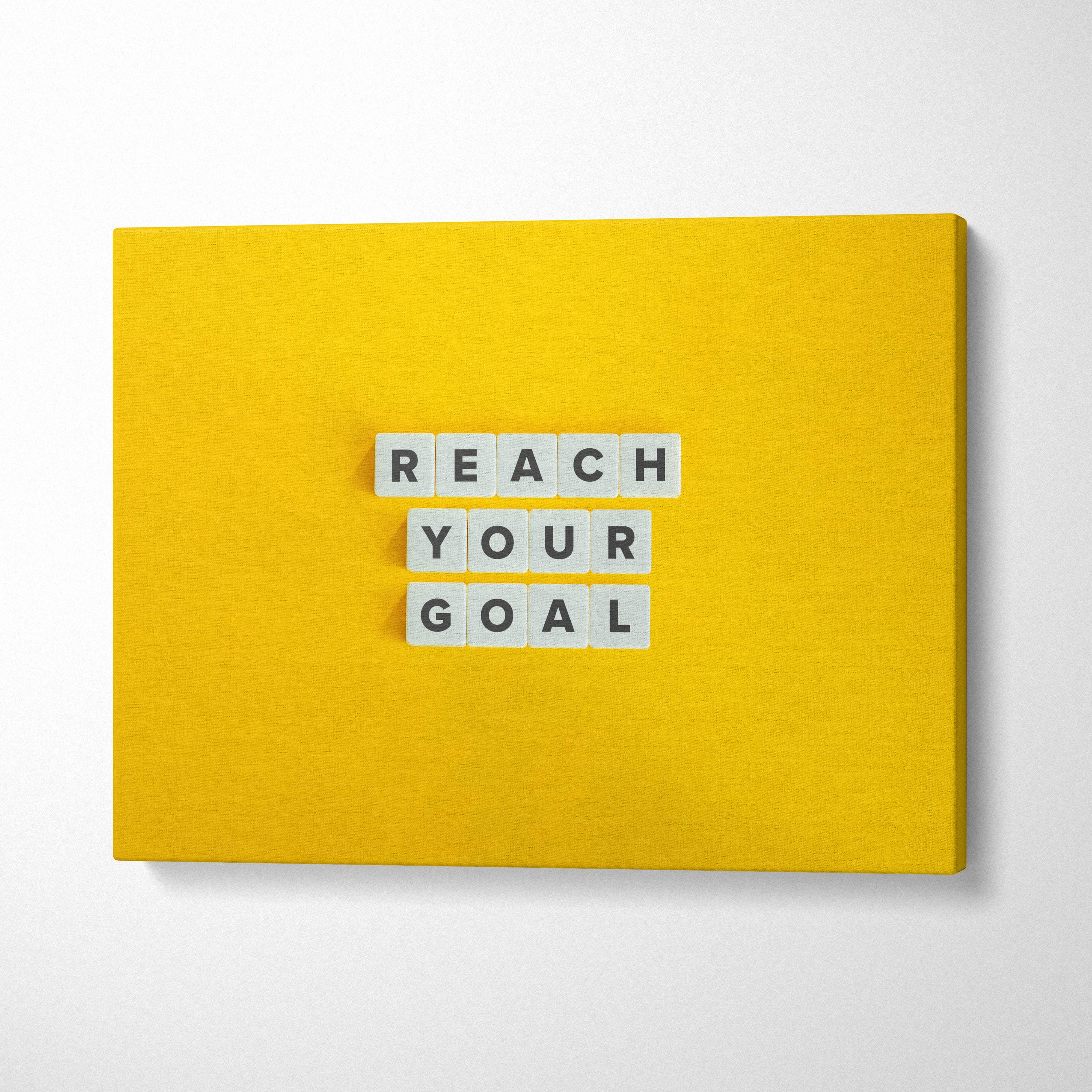 Bright yellow canvas wall art with white letter tiles spelling reach your goal inspirational success quote print