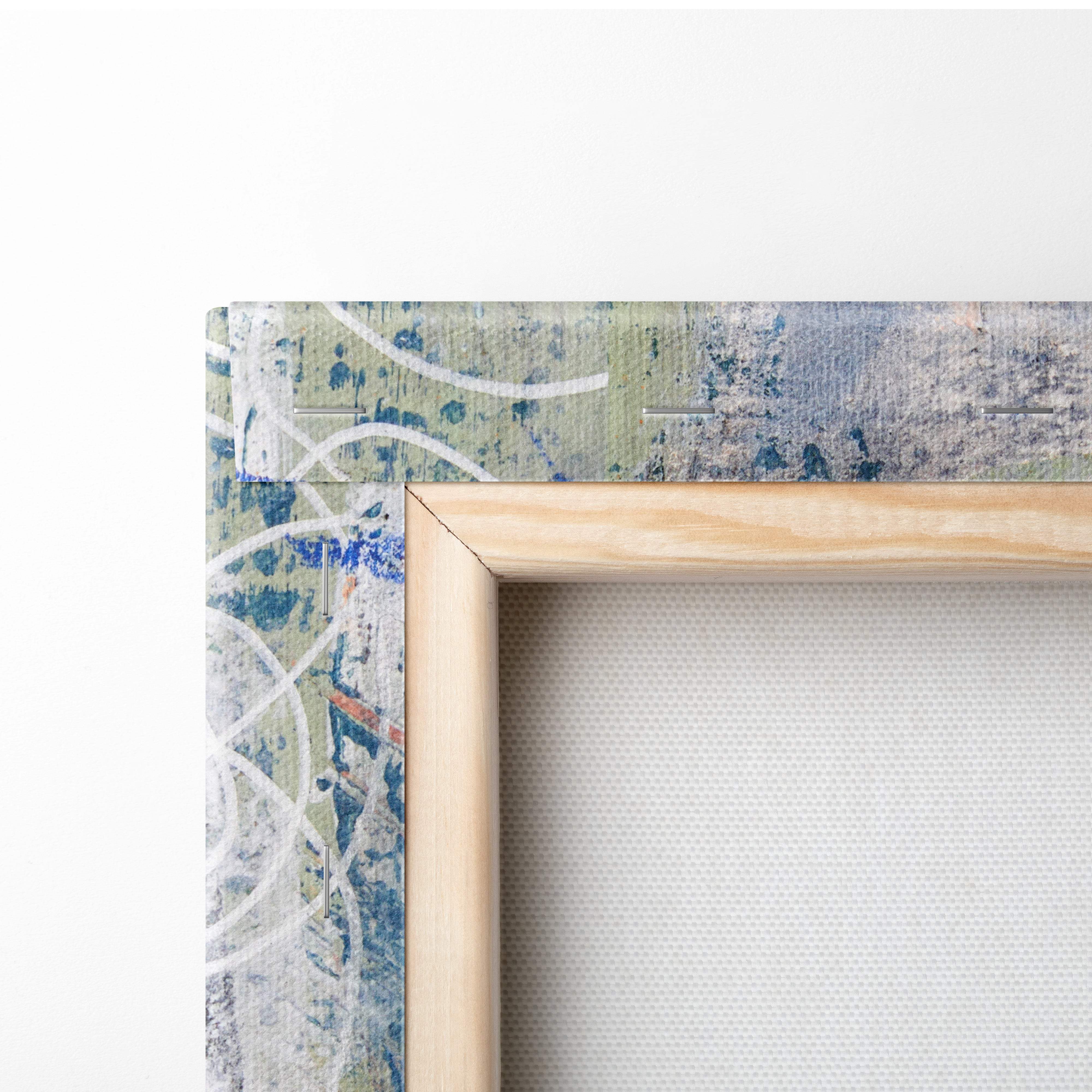 Light wooden frame holding blue coral abstract canvas wall art with blue green and white paint splatters for modern decor