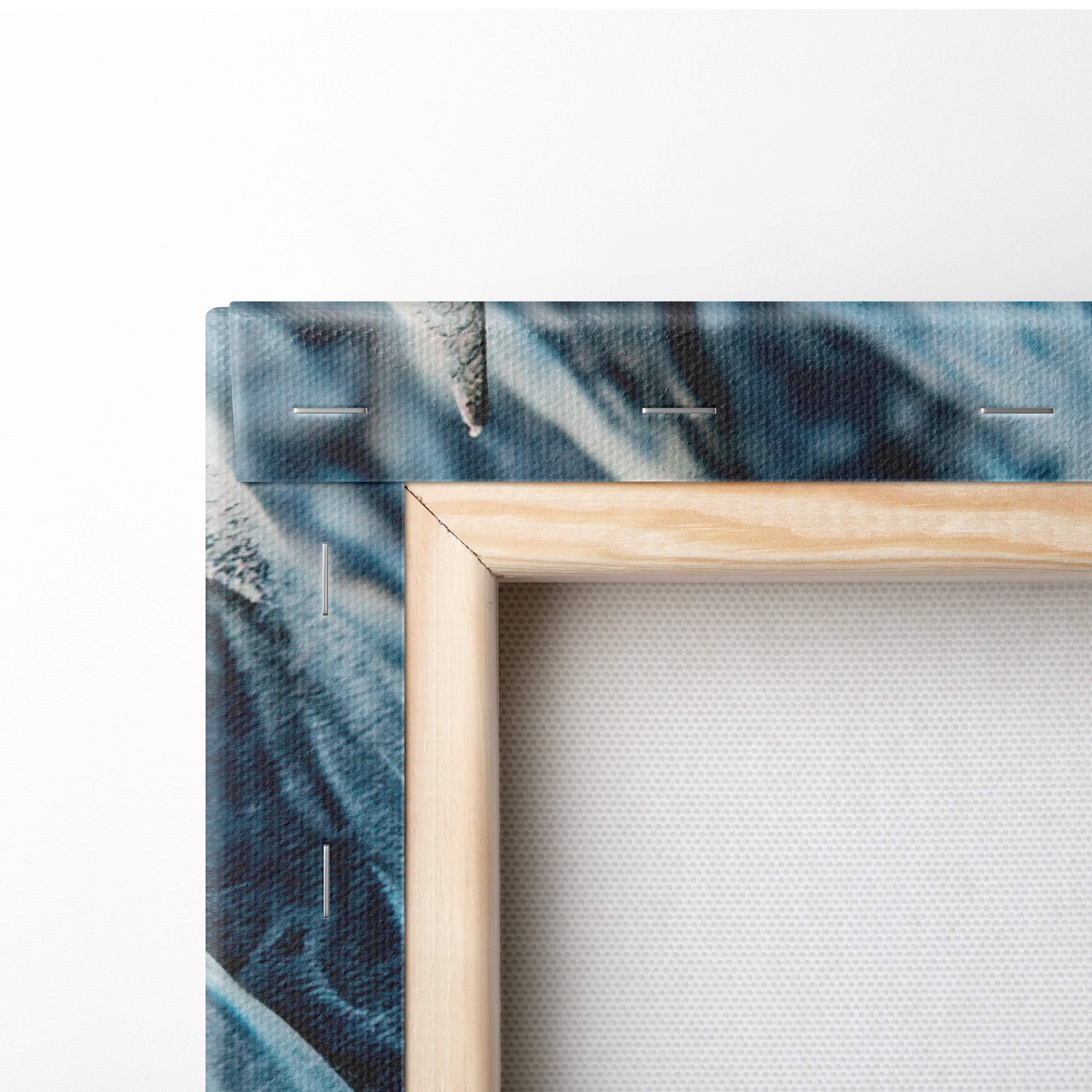 A minimalist wooden frame with light natural finish holds azure dragon eye canvas art featuring blue white swirling patterns