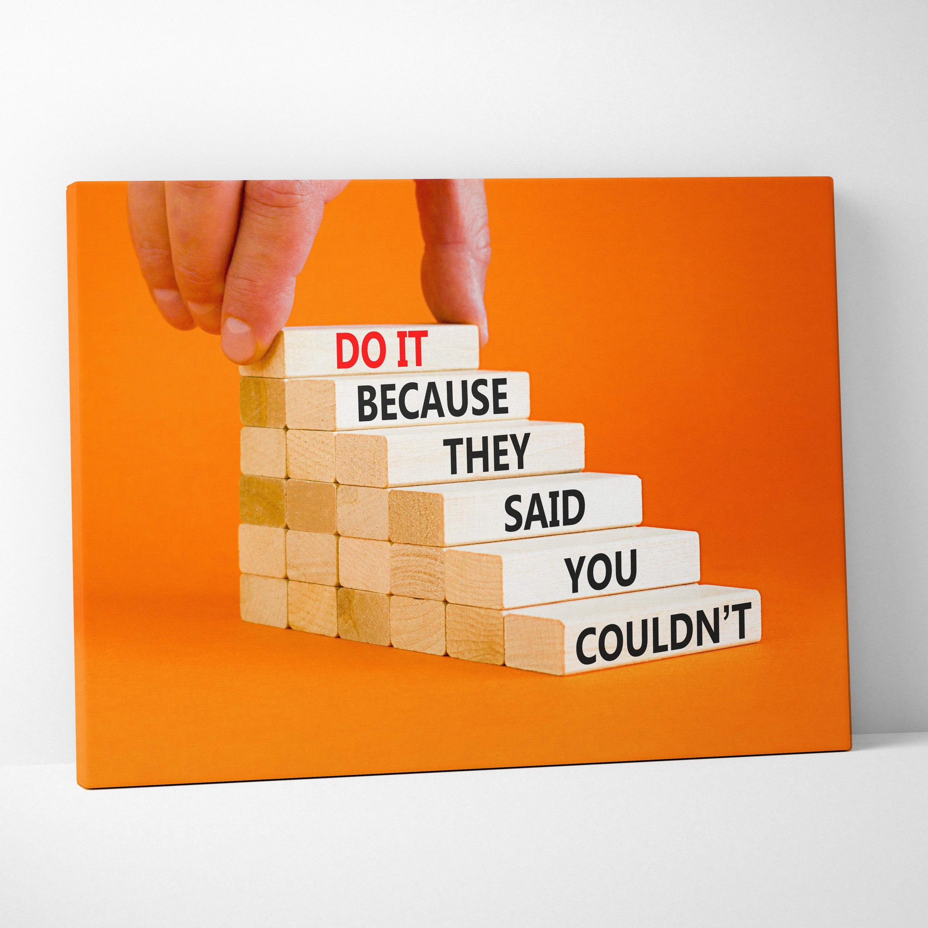 Orange canvas print showing a hand placing wooden blocks with motivational text for office gym or home decor