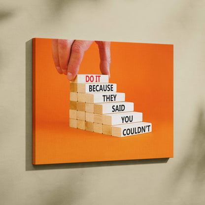 Orange canvas print featuring a hand placing a wooden block with do it because they said you couldnt motivational quote