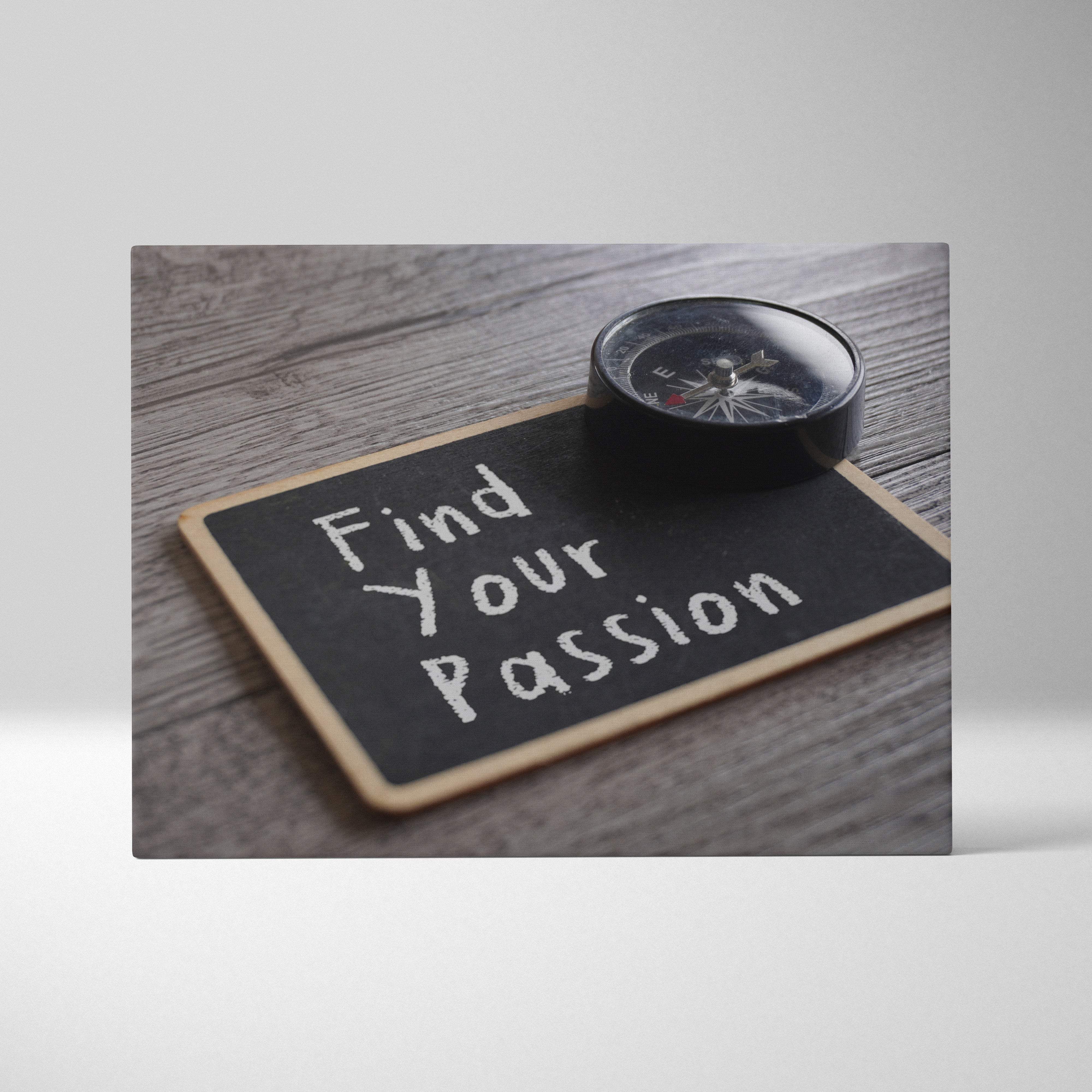 Black rectangular chalkboard wall art with wooden frame featuring find your passion quote and a black compass on surface