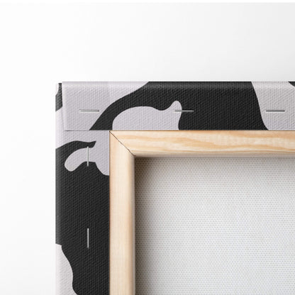 Minimalist canvas print with bold black and white cow pattern framed in light wood for living room wall art