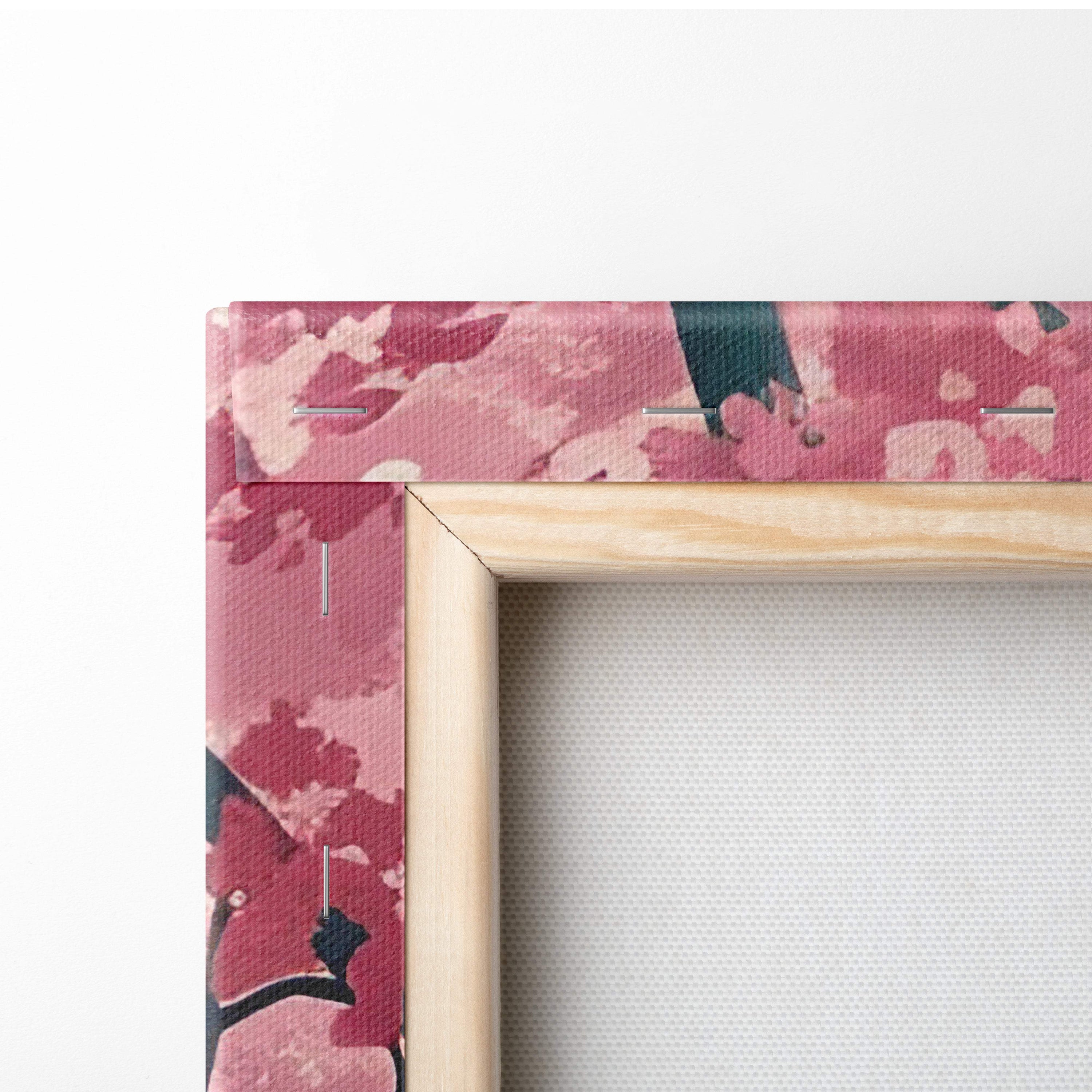 A wooden frame with a pink and black floral canvas of cherry blossom forest and teal misty trees wall art