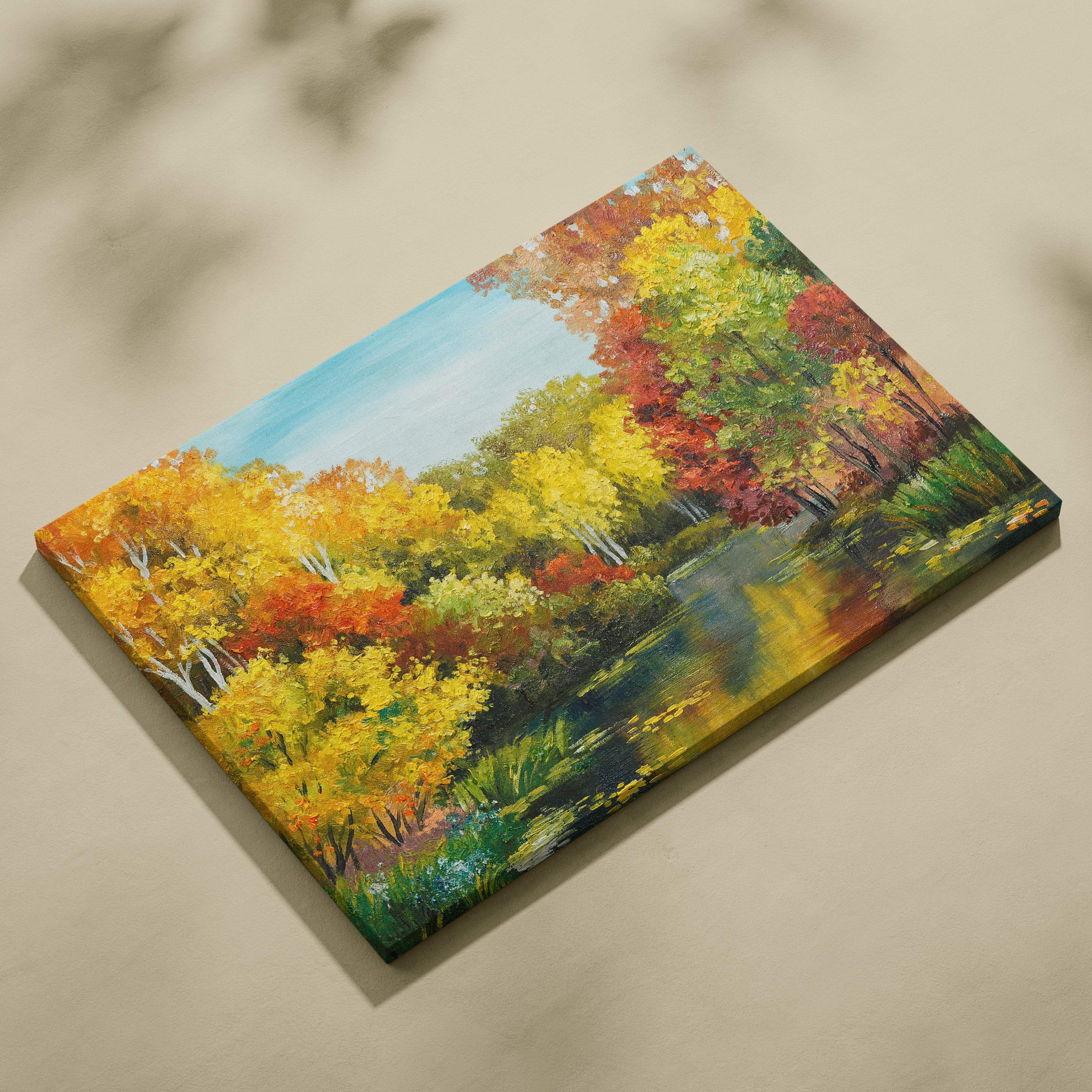 Bright autumn lake canvas wall art print of vibrant yellow orange and red trees reflected in a serene pond under blue sky