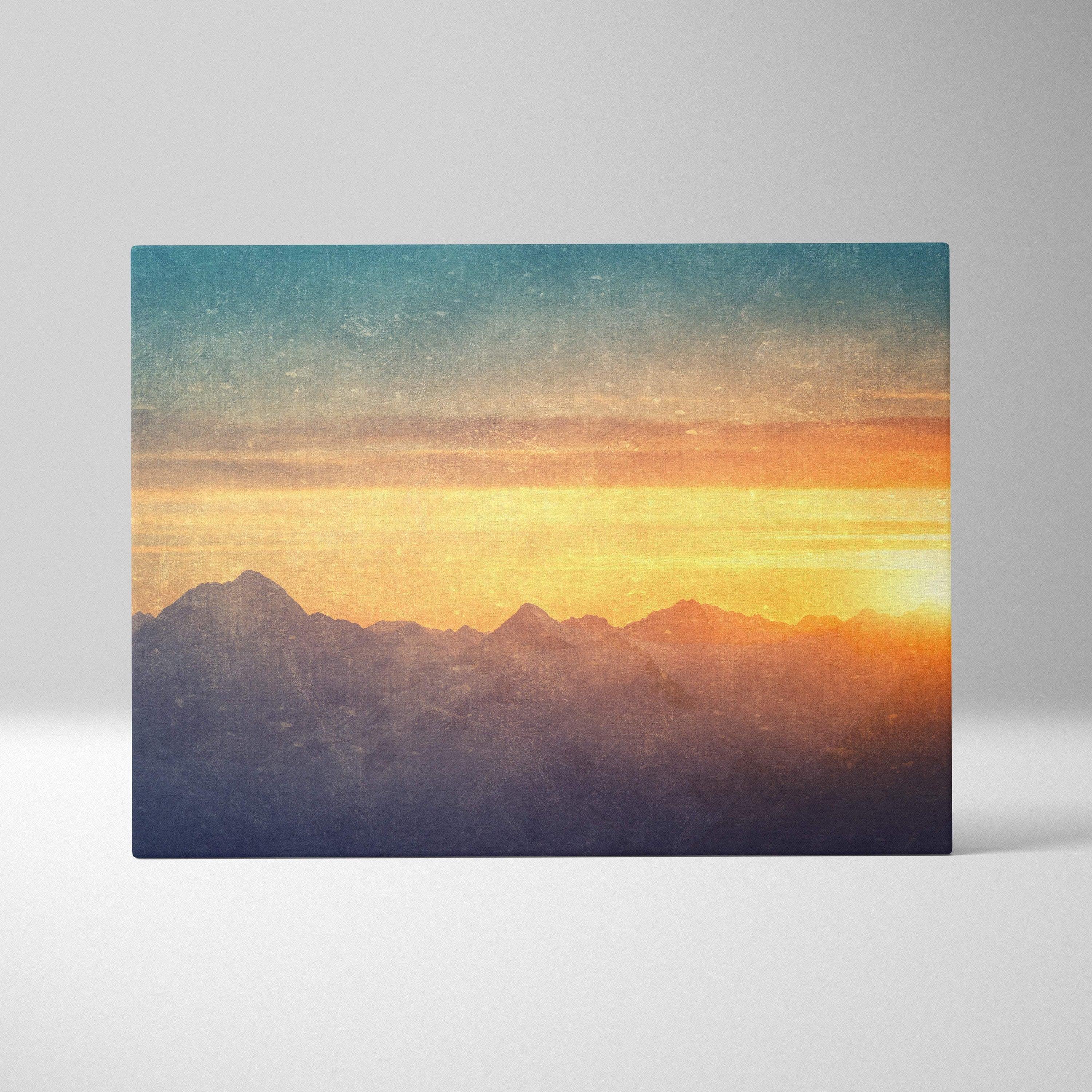 A rectangular canvas print of a golden mountain sunset with teal orange hues for rustic living room decor