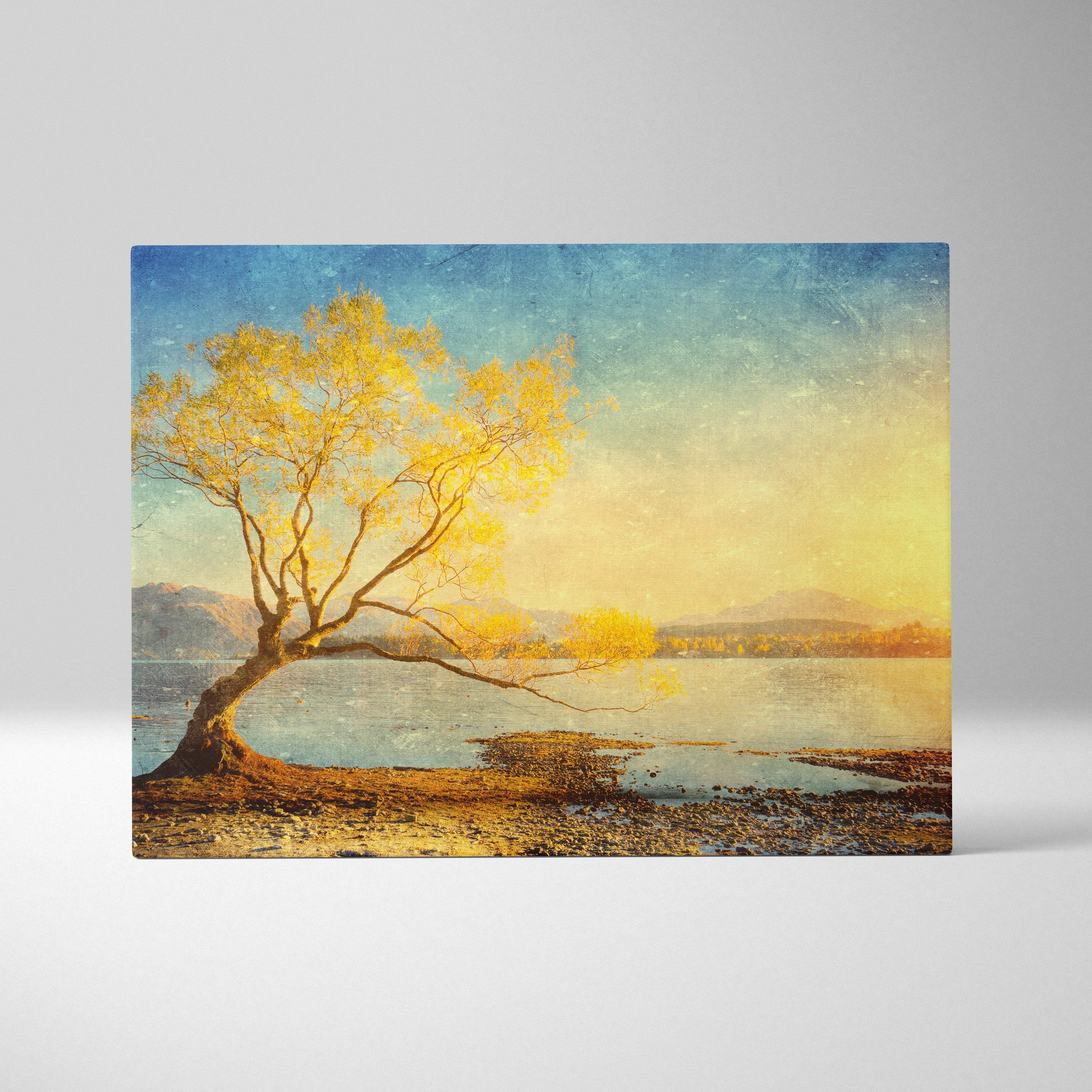 Rectangular canvas print featuring a solitary golden-yellow tree leaning over calm water with a teal blue sky background