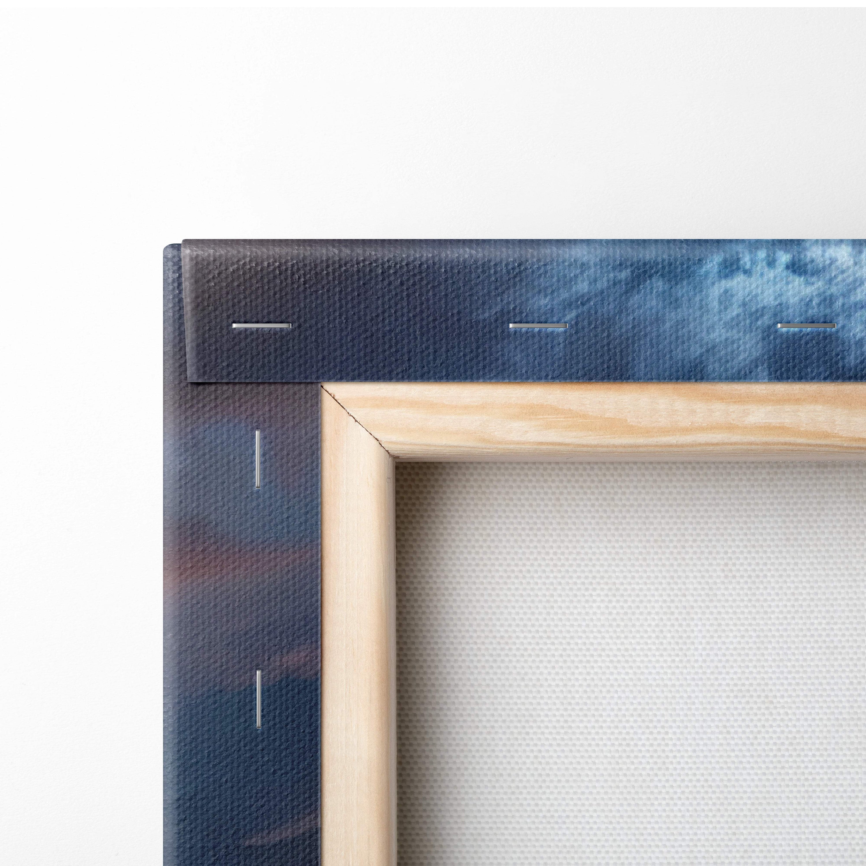A minimalist wooden frame with natural finish holding a storm over prairie house canvas art in deep blue and indigo hues
