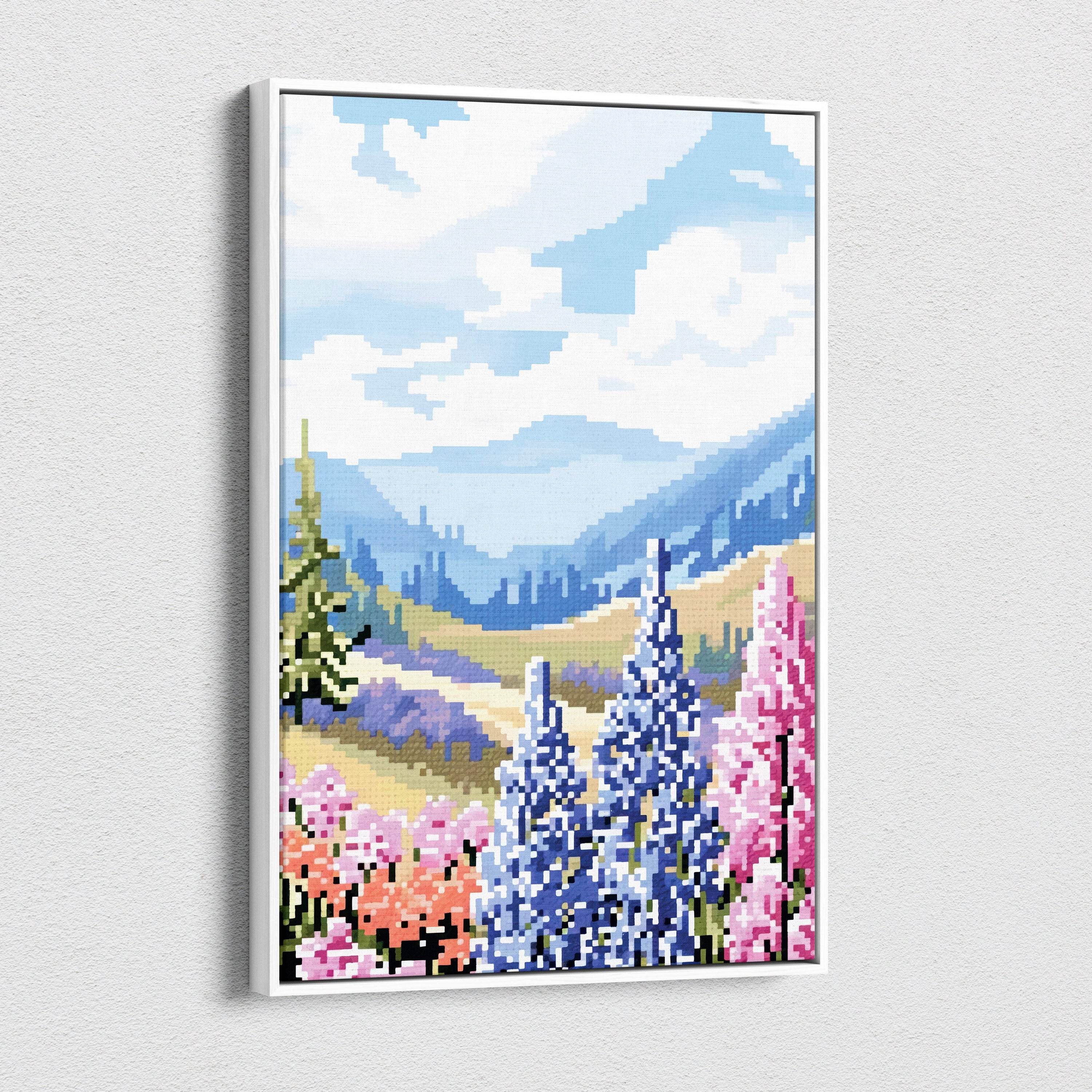 A framed pixel art landscape canvas print featuring vibrant blue and pink wildflowers with green trees and mountains
