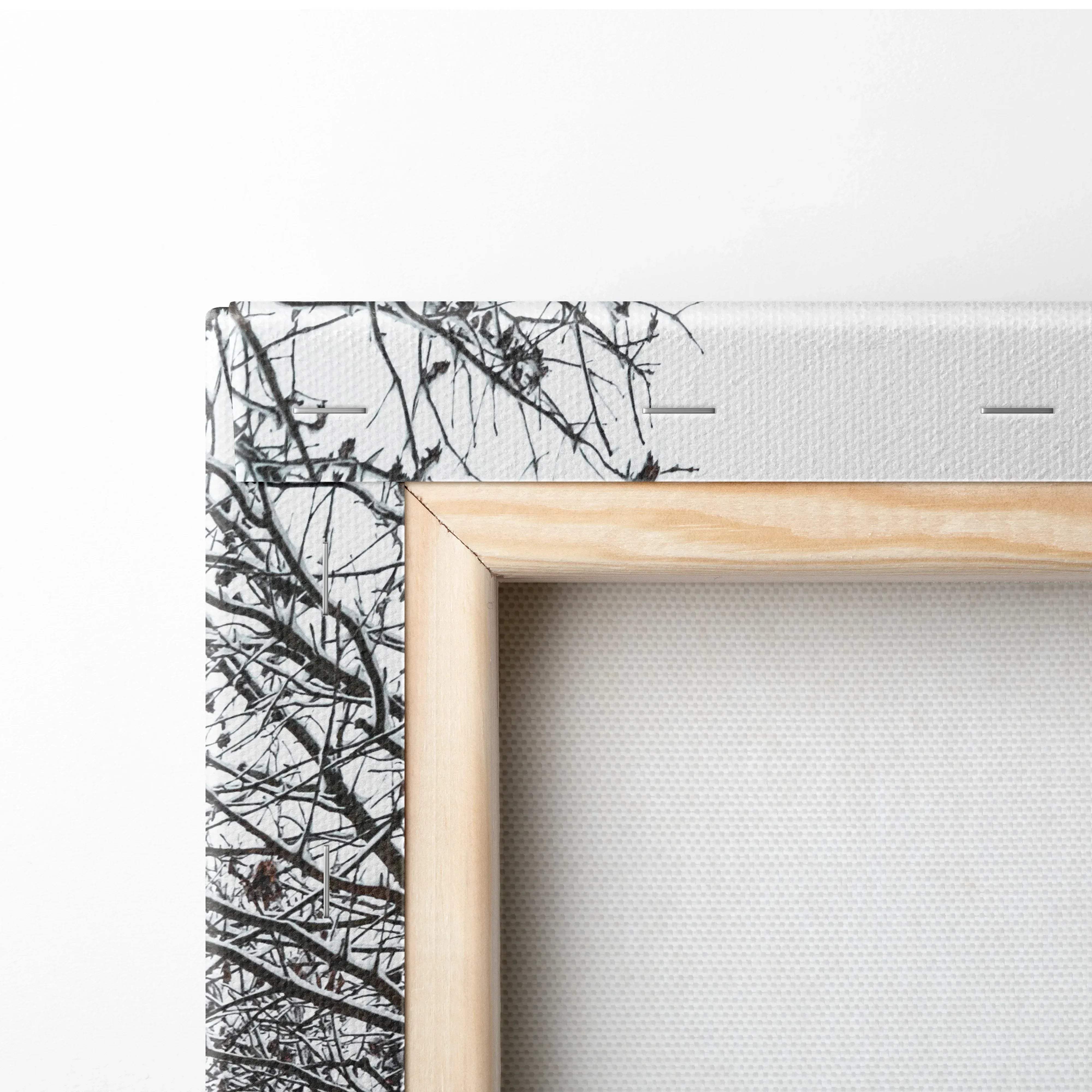 Light wood-framed canvas wall art with black-and-white branch pattern featuring snowy trees along a frosty road