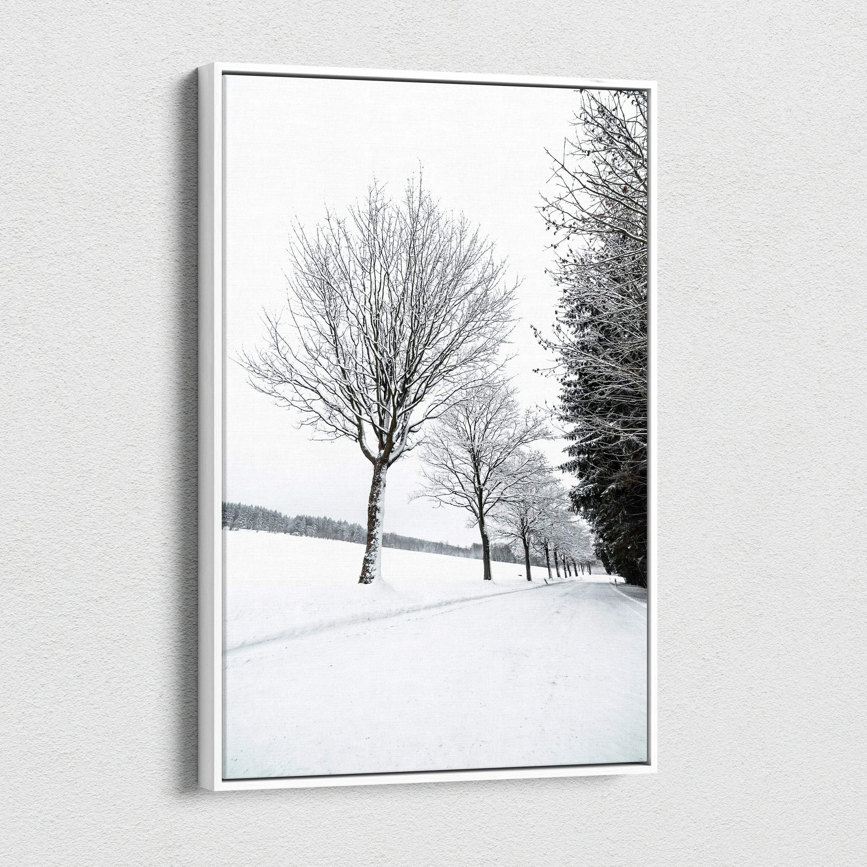 Vertical canvas wall art featuring a serene snowy landscape with bare trees, perfect winter decor.
