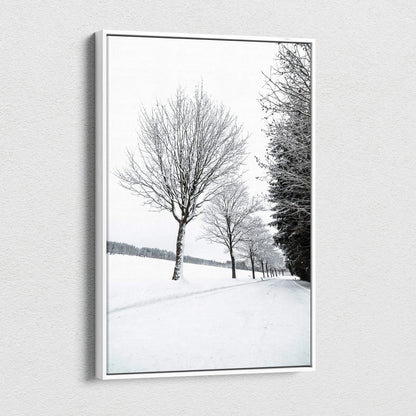 Vertical canvas wall art featuring a serene snowy landscape with bare trees, perfect winter decor.