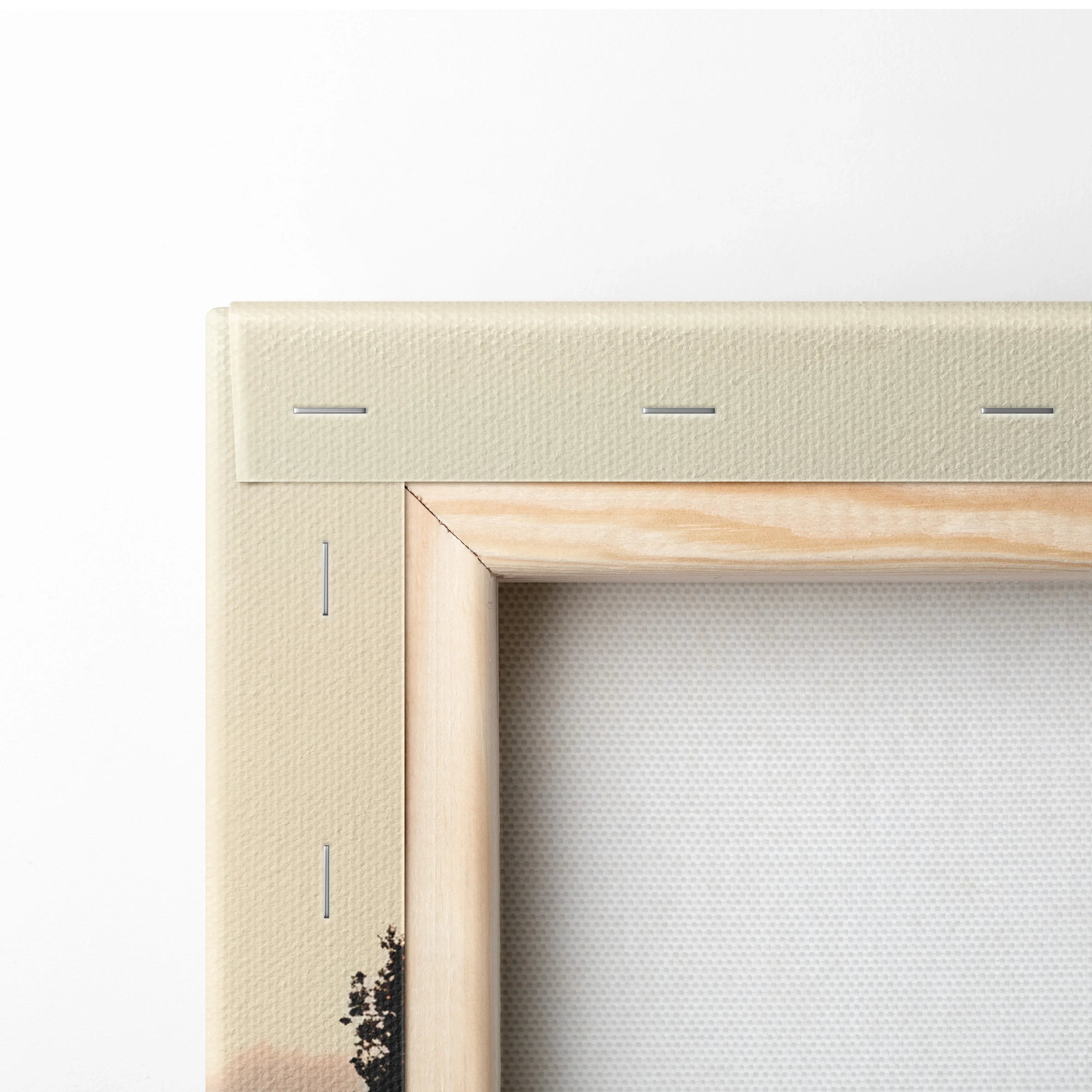 Close-up of wooden frame corner with beige canvas stretched and stapled for wall art canvas print.
