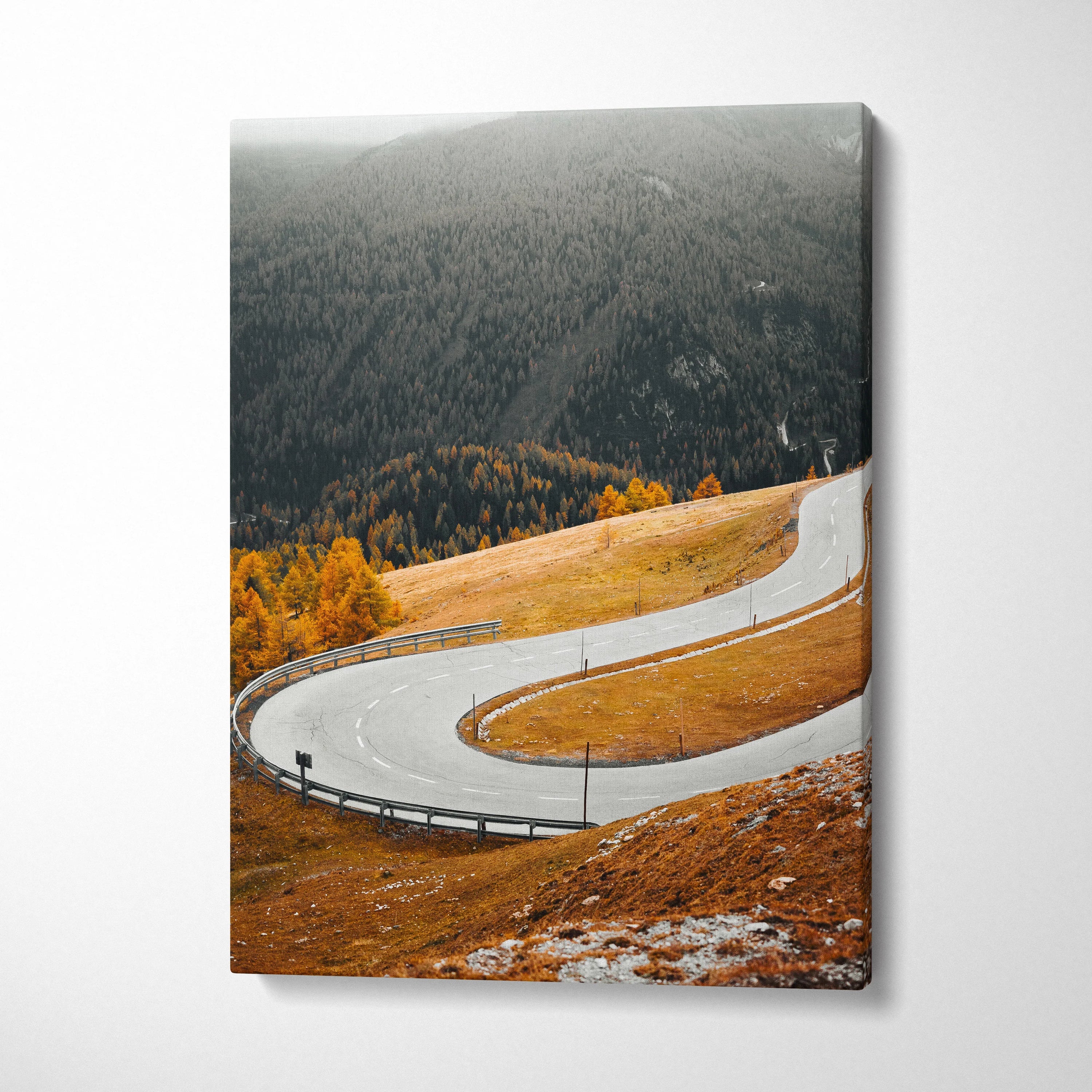 Vertical canvas art print of a winding road through vibrant autumn landscape with orange foliage and misty forest backdrop.