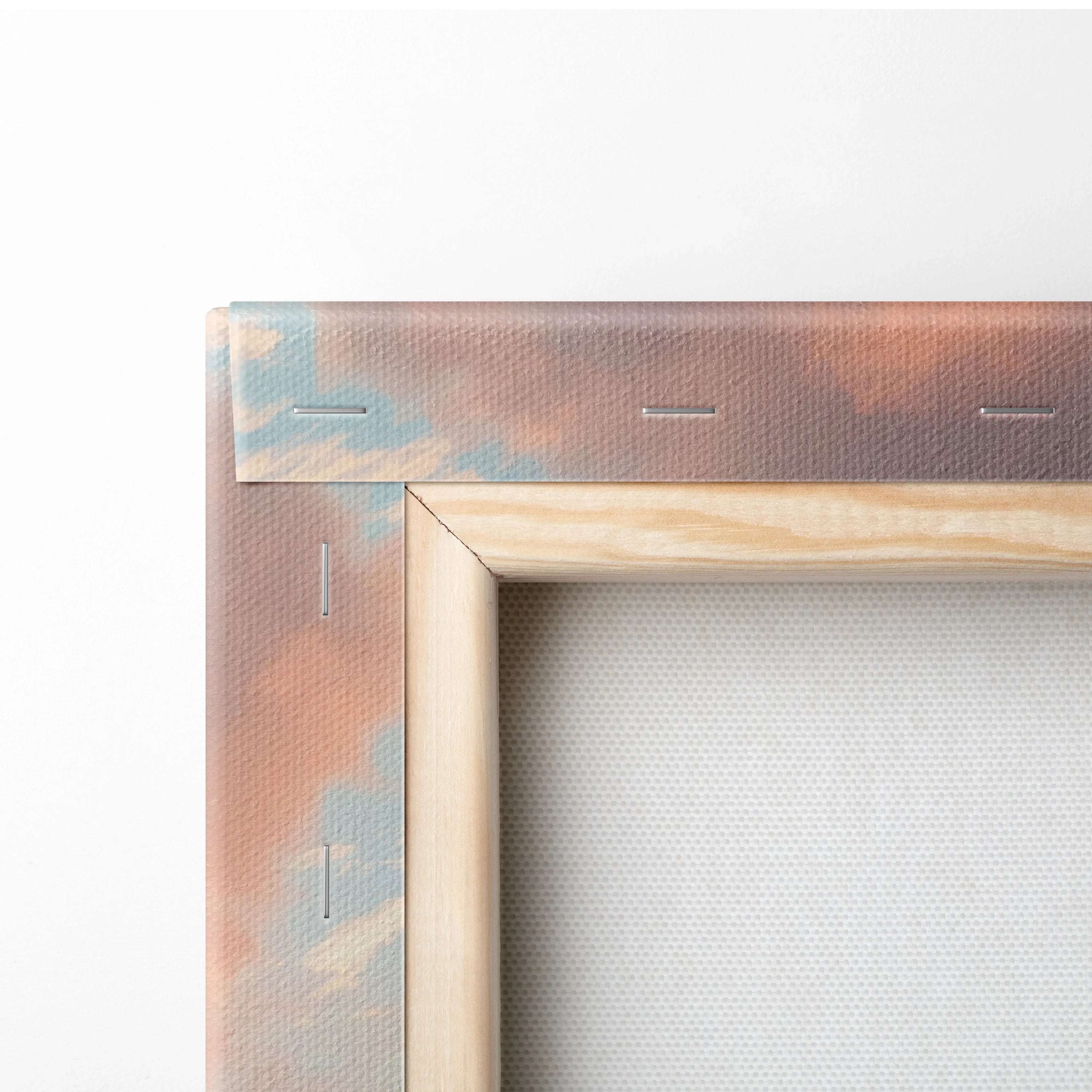 Close-up of wooden frame corner with canvas stretched over showing vibrant tropical sunset colors in sky on textured fabric.